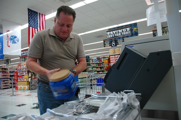 Derryl Sullivan, 325th Civil Engineer Squadron civil engineer, purchases a tub of coffee at the commissary's new self check-out lane Jan. 17.  The commissary added 4 self check-out lanes Jan. 15 and replaced nine cash registers with new ones to help speed up customer service.  (U.S. Air Force photo/Staff Sgt. Timothy R. Capling)