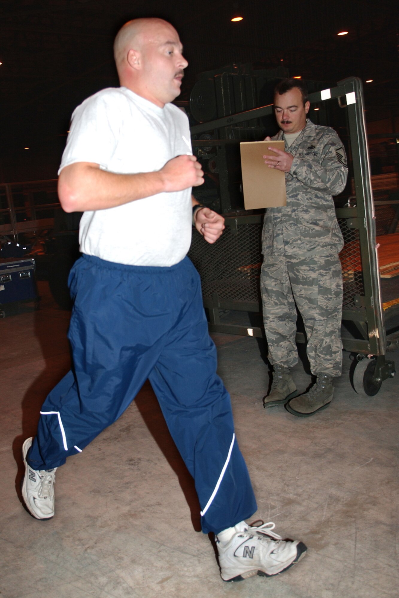 GRISSOM AIR RESERVE BASE, Ind., -- Staff Sgt. Brian Haase, a member of the 434th Security Forces Squadron, completes his fit to fight requirements inside of Hangar 592. Master Sgt. Ralph Ross, the fitness monitor for the 434th SFS, keeps track of his time and offers words of encouragement. (U.S. Air Force photo/Senior Airman Ben Mota)
