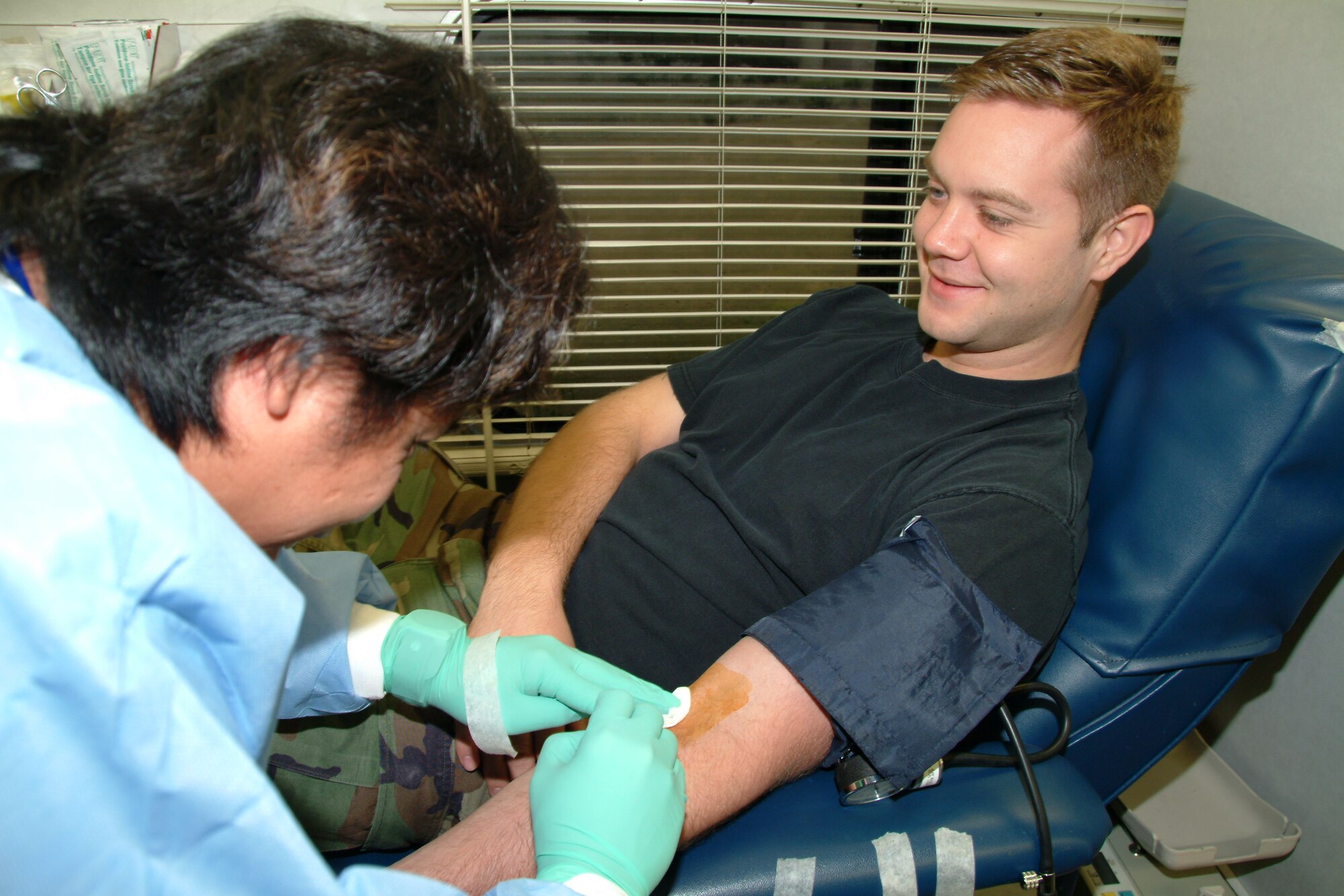 Arnold Papa, Northwest Florida Blood Center phlebotomist, removes the needle from blood donor Staff Sgt. Tommy Flynn, 36th Electronic Warfare Squadron ALQ-131 mission data specialist, Wednesday during the 53d Wing blood drive at Eglin Air Force Base.  Air Force photo by Capt. Carrie Kessler.