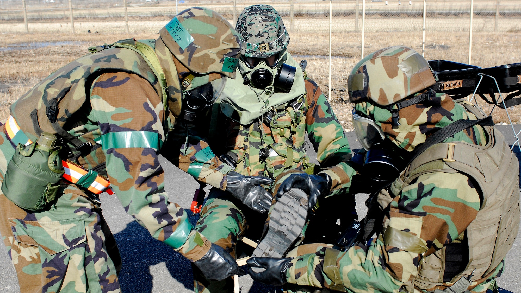 8th Security Forces Squadron Airmen assist a South Korean army soldier with decontamination of his gears during a peninsula-wide operations readiness exercise Jan 16 at Kunsan Air Base, South Korea. South Korean army soldiers and 8th Security Forces Squadron members demonstrate the teamwork necessary to carry out the combined mission of the two allies stationed at Kunsan AB. (U.S. Air Force photo/Senior Airman Giang Nguyen) 

