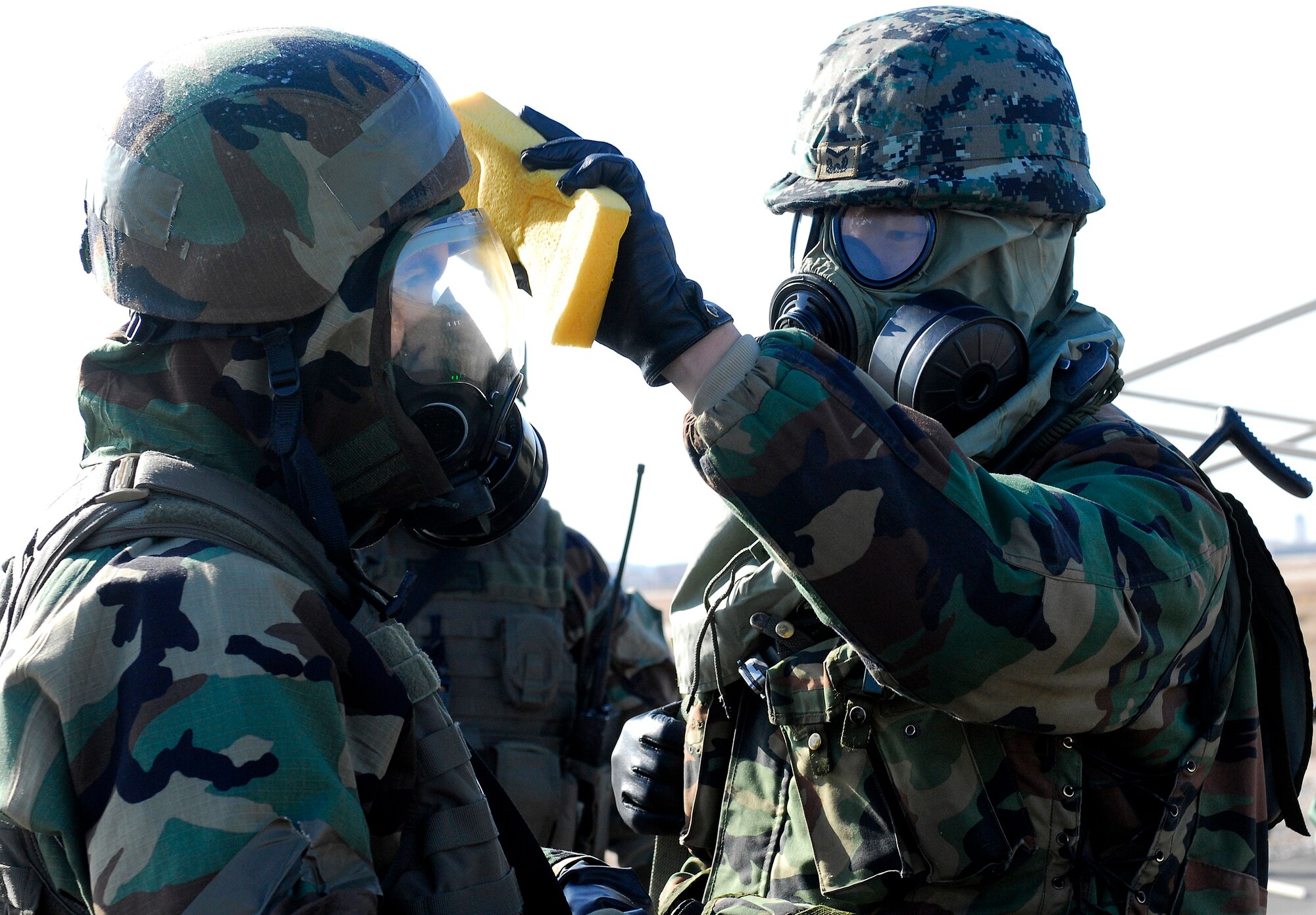 A South Korean army soldier from 7th Brigade Special Forces helps his American counterpart during a decontamination process Jan. 16 at Kunsan Air Base, South Korea. South Korean army soldiers and 8th Security Forces Squadron members demonstrate the teamwork necessary to carry out the combined mission of the two allies stationed at Kunsan AB during a peninsula-wide operations readiness exercise. (U.S. Air Force photo/Senior Airman Giang Nguyen) 
