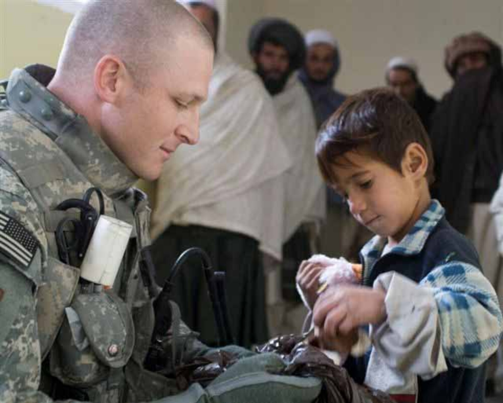 Tech. Sgt. Brandon Bowen, 72nd Medical Group, helps hand out food to refugees while on a humanitarian assistance mission.  Sergeant Bowen is currently deployed with the Army in support of Operation Eduring Freedom.  (Courtesy photo)