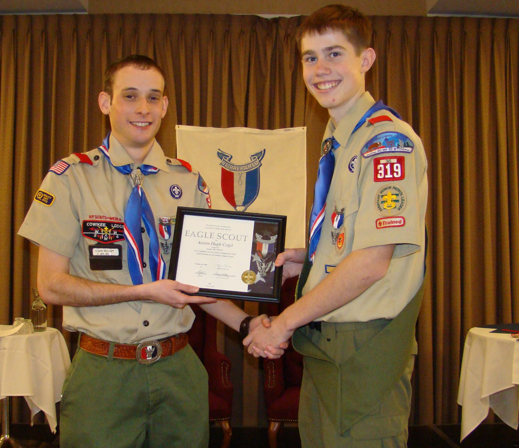 GRAND FORKS AIR FORCE BASE ND - Austin Cogil (right) receives a certificate recognizing his achievement of reaching the rank of Eagle Scout from Troop 319 Scout Master Senior Airmen Chad Kellum.