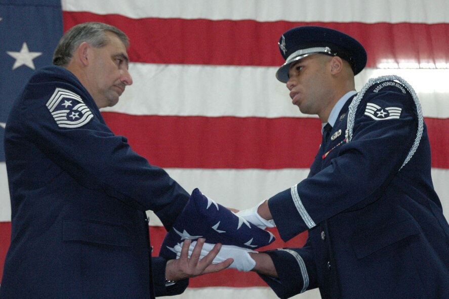 YOUNGSTOWN AIR RESERVE STATION, Ohio — Air Force Reserve Chief Master Sgt. Robert V. Glus Sr., command chief master sergeant of the 910th Airlift Wing, accepts a United States flag from Staff Sgt. Courtenay Perkins, a member of the 910th Airlift Wing Honor Guard, during a Jan. 6, 2008 ceremony marking the chief's retirement from the Air Force Reserve. Chief Glus retired after 26 years of service with the 910th and 33 total years of military service. U.S. Air Force photo/Tech. Sgt. Bob Barko Jr.