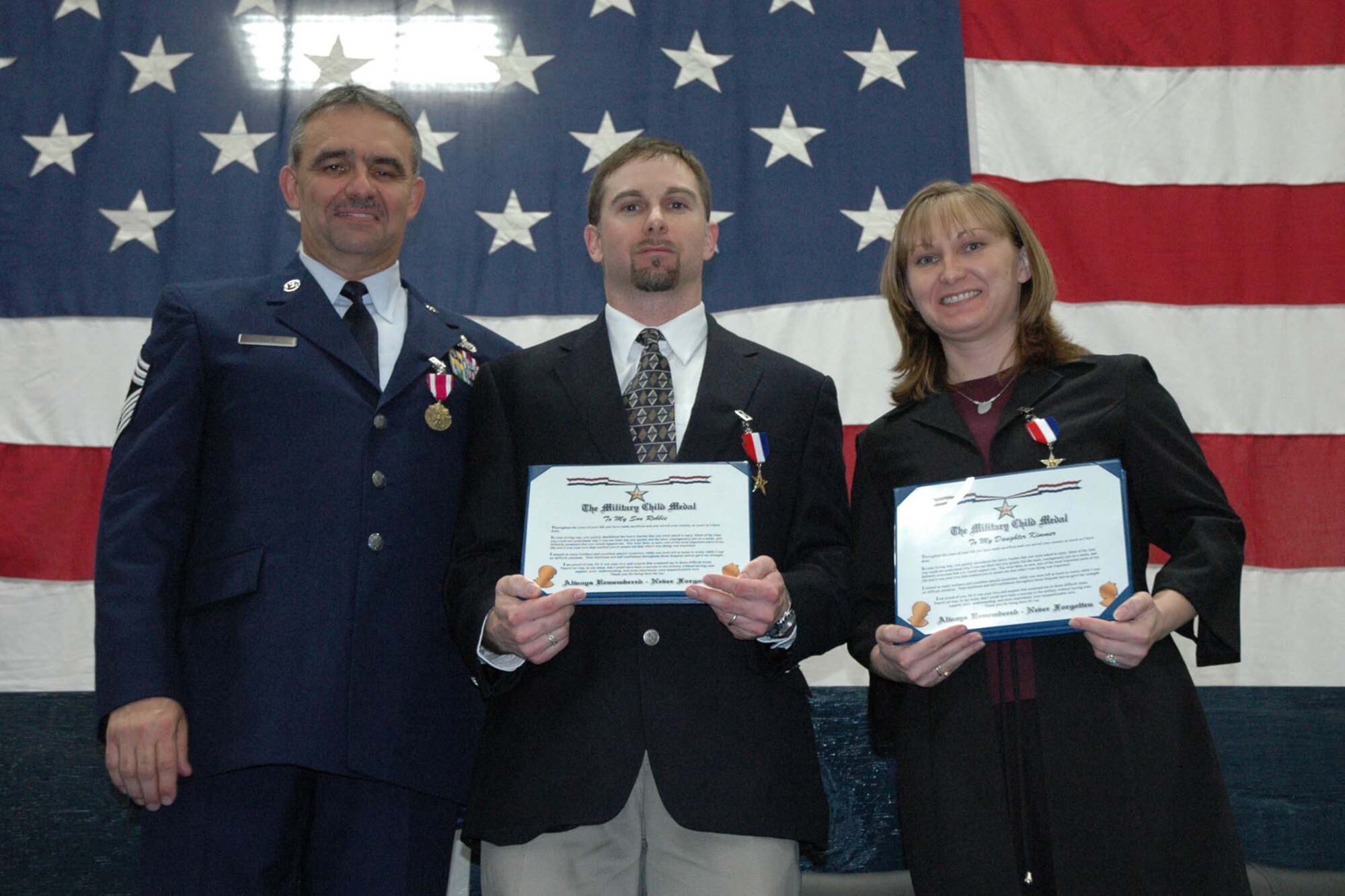 YOUNGSTOWN AIR RESERVE STATION, Ohio -- Air Force Reserve Chief Master Sgt. Robert V. Glus Sr., command chief master sergeant of the 910th Airlift Wing, presents the Military Child Medal to his son Robbie and his daughter Kimberly, at the chief's retirement ceremony Jan. 6. 2008. U.S. Air Force photo/Tech. Sgt. Bob Barko Jr.