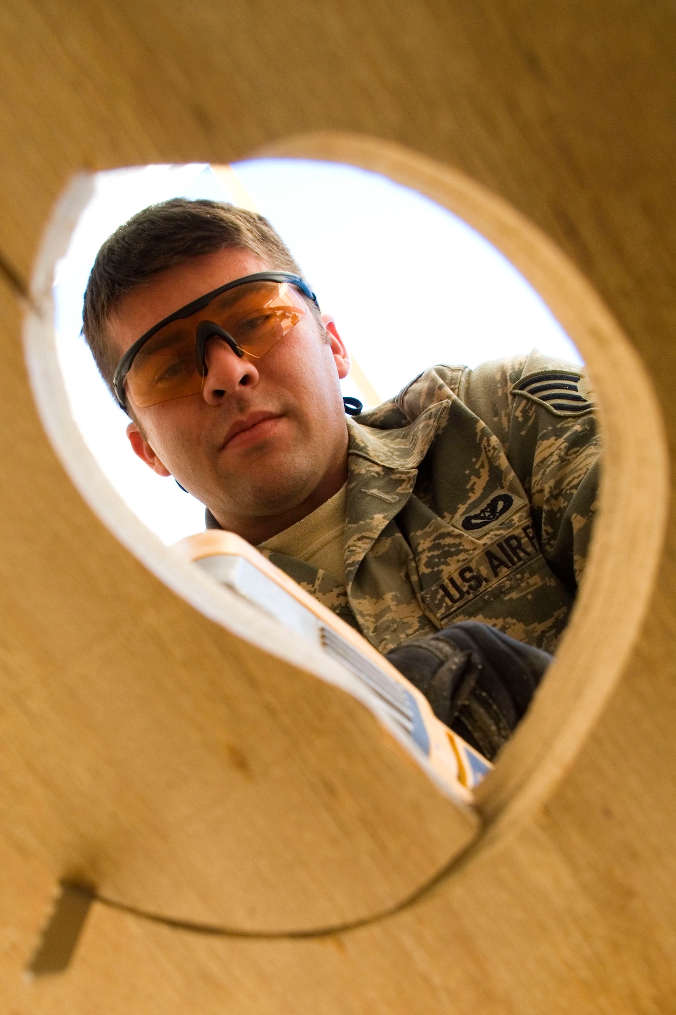 Staff Sgt. Caleb Dennis saws a drainage hole for a shower latrine unit Jan. 15 at Balad Air Base, Iraq. The unit is a prototype to be used at forward operating bases throughout Iraq. Sergeant Dennis, a 732nd Expeditionary Civil Engineer Squadron utility technician, is deployed from Kadena Air Base, Japan. (U.S. Air Force photo/Staff Sgt. Joshua Garcia)