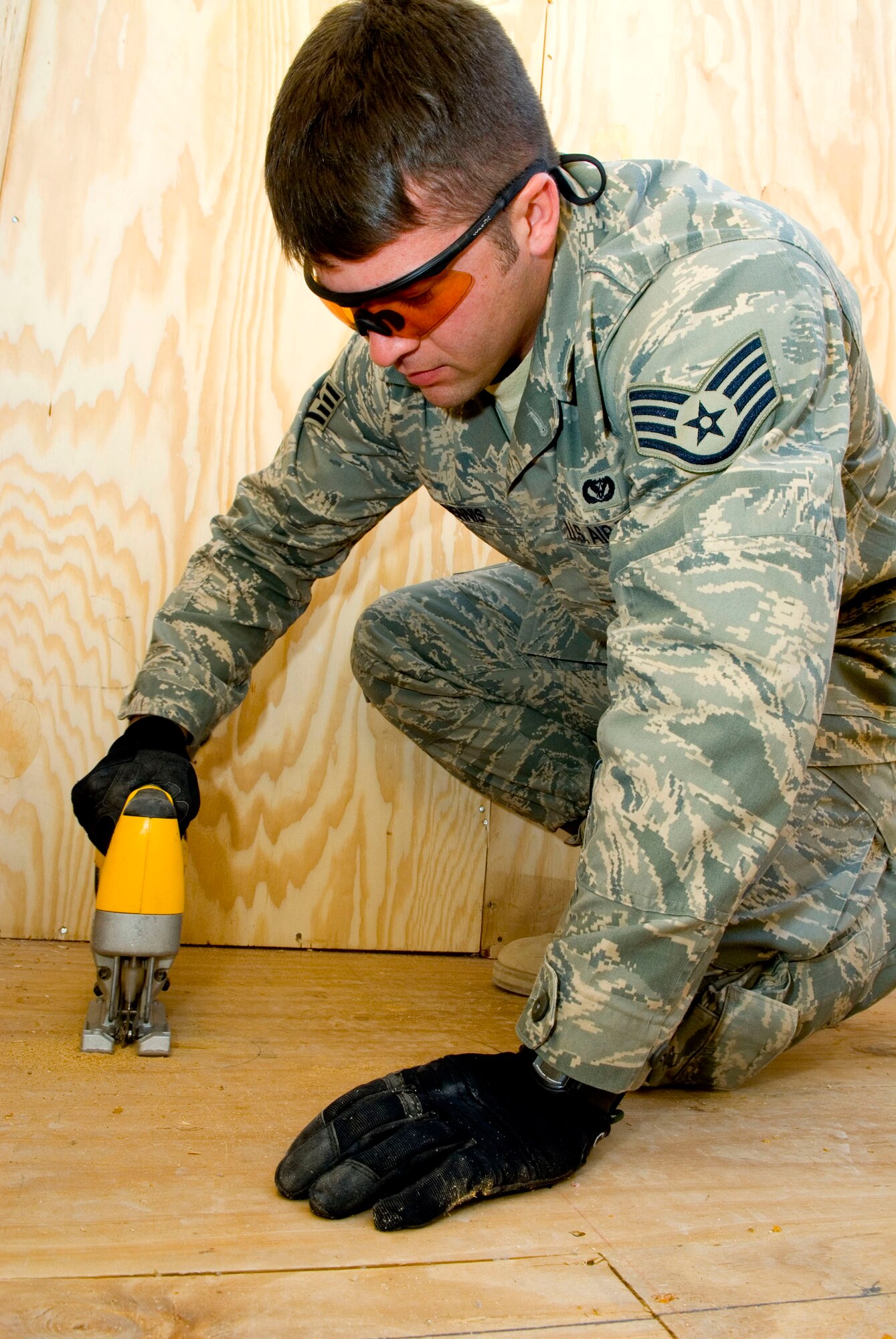 Staff Sgt. Caleb Dennis cuts a hole into a shower latrine unit Jan. 15 at Balad Air Base, Iraq. The hole will be used to install drainage pipes in the unit. Sergeant Dennis, a 732nd Expeditionary Civil Engineer Squadron utility technician, is deployed from Kadena Air Base, Japan. (U.S. Air Force photo/Staff Sgt. Joshua Garcia)
