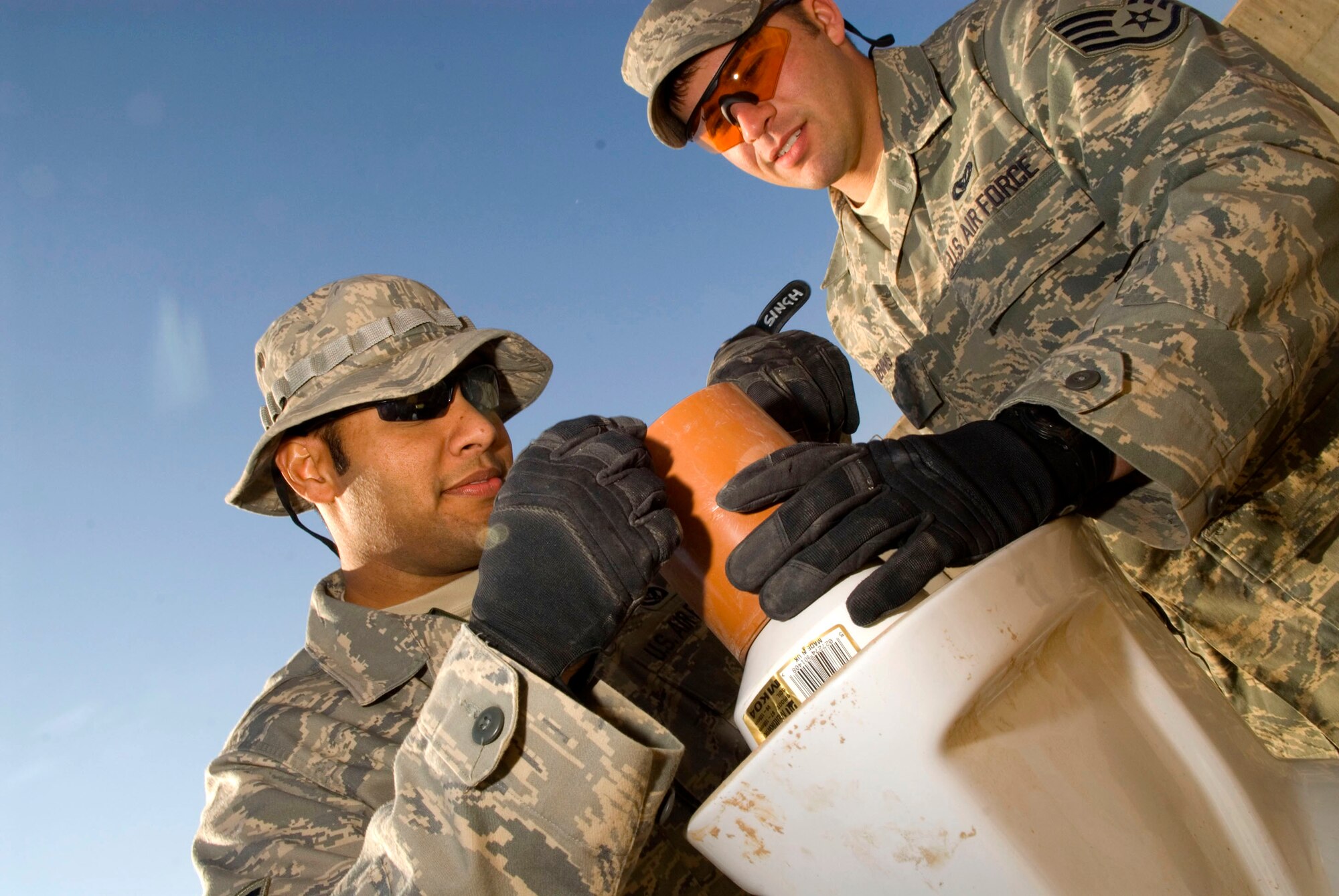 Staff Sgts. Pranay Singh and Caleb Dennis, , connect a seal to a toilet Jan. 15 at Balad Air Base, Iraq. The seal prevents water from leaking out of the drain pipes. Sergeants Singh and Dennis, both 732nd Expeditionary Civil Engineer Squadron utility technicians, are deployed from Kadena Air Base, Japan. (U.S. Air Force photo/Staff Sgt. Joshua Garcia)
