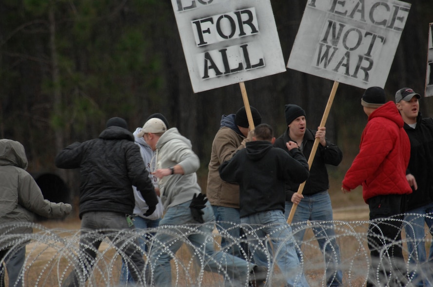 MOODY AIR FORCE BASE, Ga. -- Airmen playing mock protestors get engaged by the Active Denial System Jan. 12 here. The Airmen were performing scenarios for CBS News' 60 Minutes and the History Channel's Modern Marvels. (U.S. Air Force photo by Airman 1st Class Gina Chiaverotti)