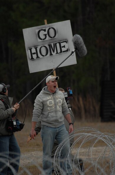 MOODY AIR FORCE BASE, Ga. -- An Airman playing a mock protestor is recorded by the 60 Minutes crew Jan. 12 here. The film crew was filming the employment of the Active Denial System for an upcoming segment on non-lethal weapons technologies. (U.S. Air Force photo by Airman 1st Class Gina Chiaverotti)