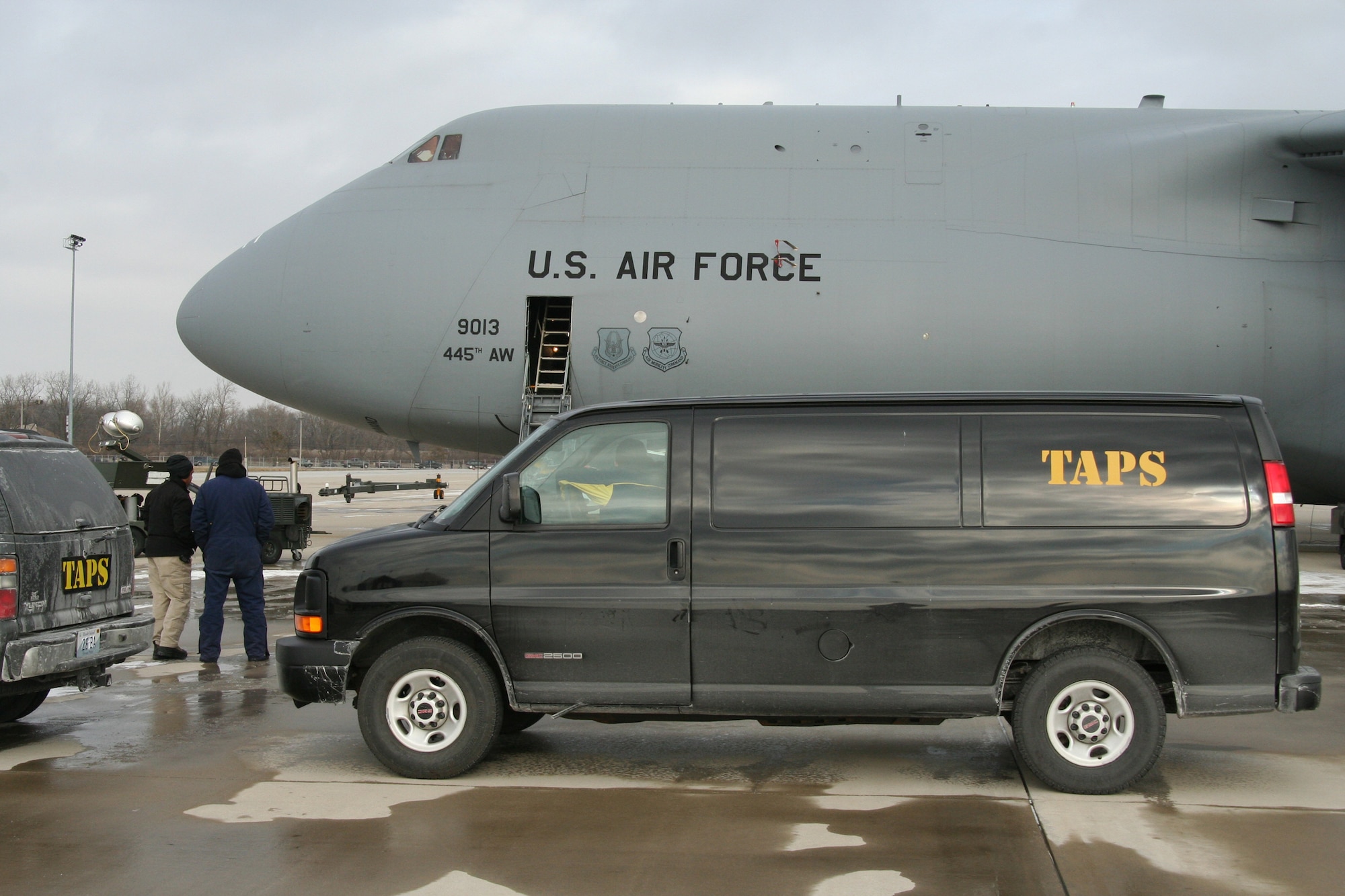WRIGHT-PATTERSON AFB, Ohio - The Atlantic Paranormal Society (TAPS) van sits in front of a 445th Airlift Wing C-5. The popular Sci Fi Channel T.V. show Ghost Hunters is filming their show in several buildings at Wright-Patterson AFB and filmed some footage of the 445th Airlift Wing's C-5 Galaxy Jan. 15, 2008 to help enhance the Air Force base setting for the show. (U.S. Air Force photo/Laura Darden)