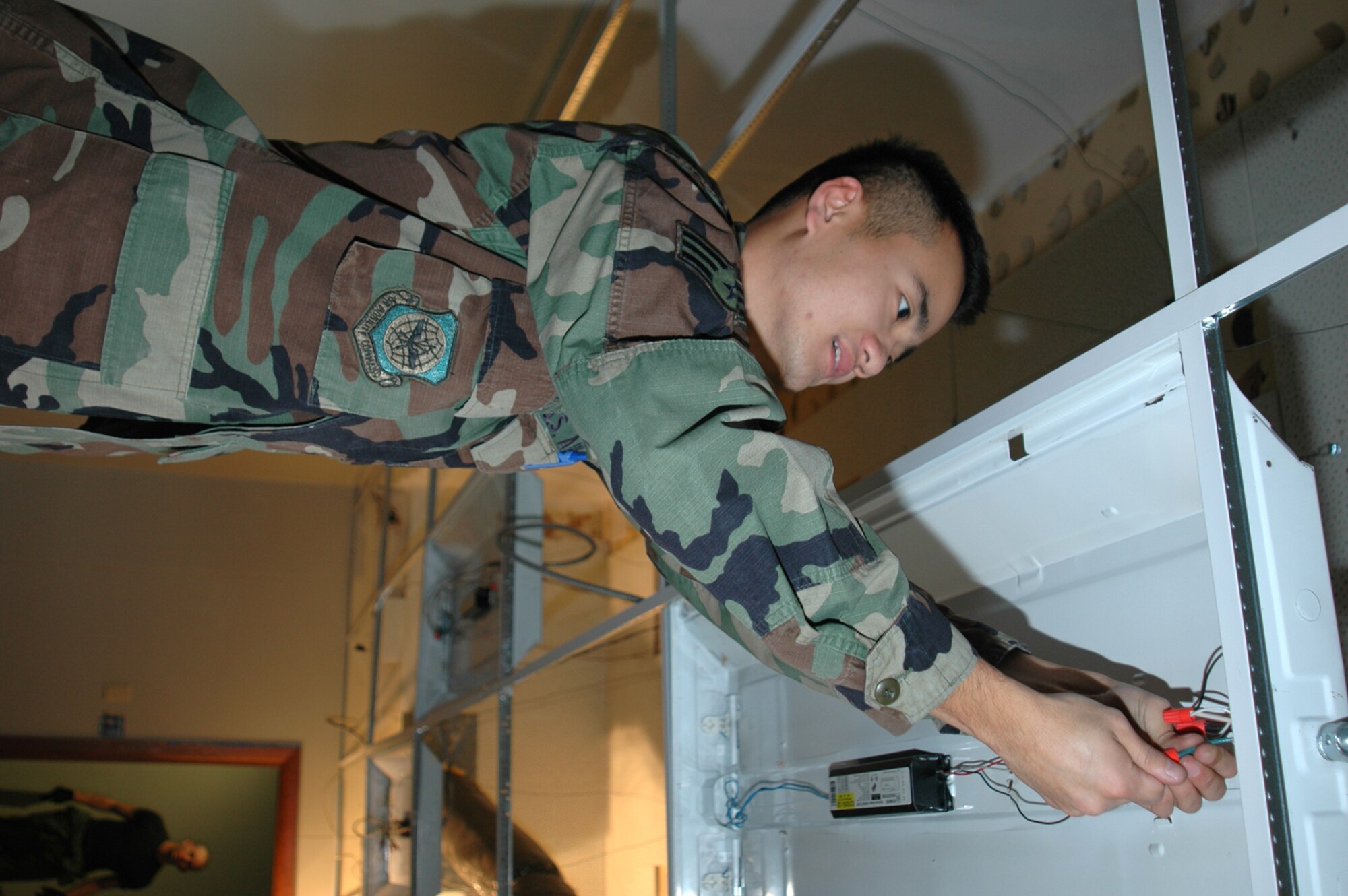 GRISSOM AIR RESERVE BASE, Ind., -- Senior Airman Loinn Htaik, a heating, ventilation and air conditioning journeyman with the 434th Civil Engineers Squadron, wires a light during renovations on base. (U.S. Air Force photo/SrA. Ben Mota)