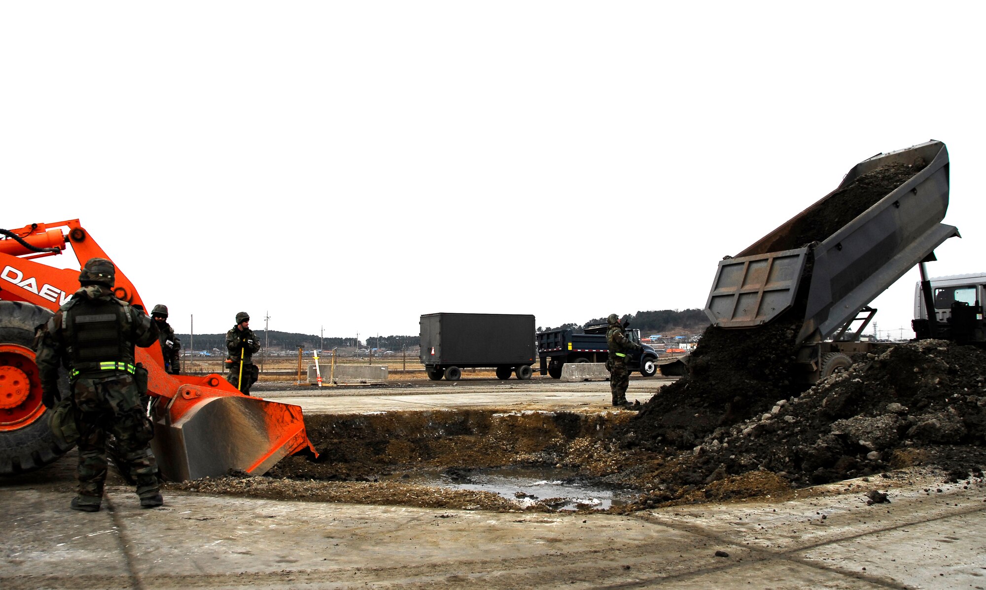 KUNSAN AIR BASE, South Korea -- Members of the 8th Civil Engineer Squadron conduct airfield damage repair during a peninsula wide operations readiness exercise (PENORE) here Jan 17.  The PENORE is conducted to ensure members of the Wolf Pack remain ready to execute the mission of maintaining peace and stability in the region.  (U.S. Air Force photo/Tech Sgt. Quinton T. Burris)
