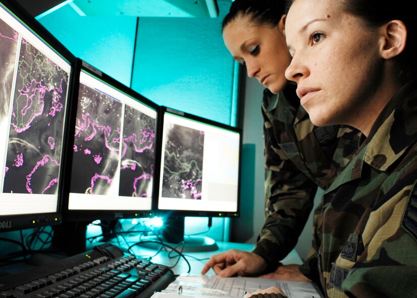 Staff Sgt. Lindsey Flaugher (front), from Wilmington, N.C., and Senior Airman Cassandra Napolitano-Romero, from Lynchburg, Va., go over Meteorological Satellite imagery. Both are METSAT analysts with the 2nd Weather Squadron at Offutt Air Force Base, Neb. (Photo  by G. A. Volb)