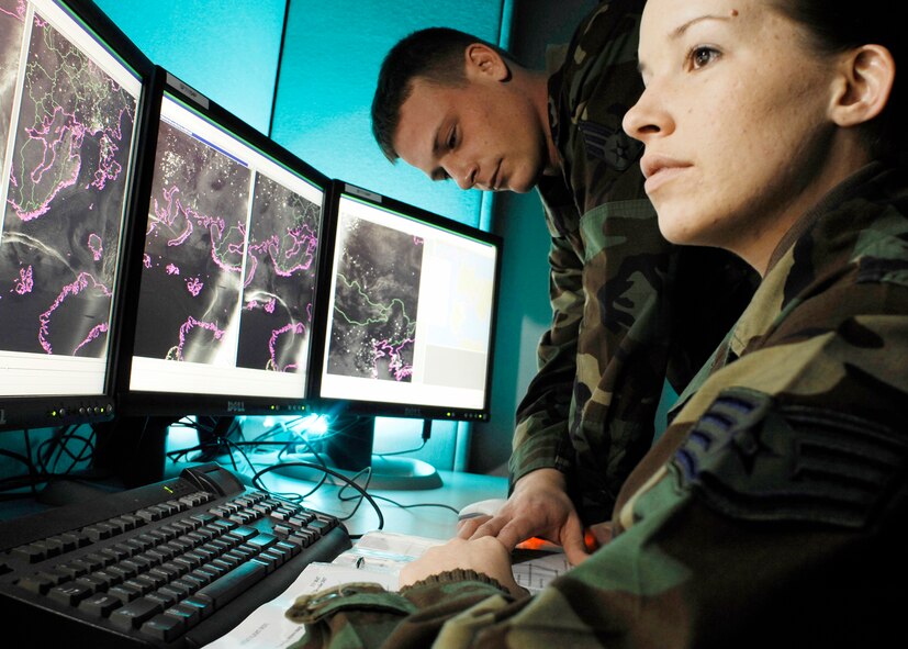 Staff Sgt. Lindsey Flaugher, from Wilmington, N.C., and Senior Airman Steven Stolze, from Brainard, Neb., go over Meteorological Satellite imagery. Both are METSAT analysts with the 2nd Weather Squadron at Offutt Air Force Base, Neb. (Photo  by G. A. Volb)