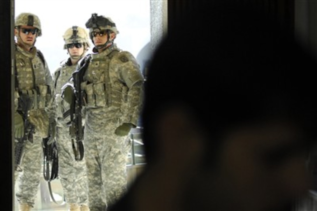 U.S. Army soldiers watch though a door as artifacts are delivered to Q'shla Museum in Kirkuk, Iraq, on Jan. 15, 2008.  The 400 to 2000-year-old artifacts were found during an excavation project on Forward Operating Base Warrior.  