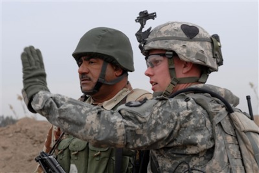 U.S. Army Sgt. 1st Class Calvin Overway talks with an Iraqi army soldier during a mission to clear insurgents from the Chaka Four region south of Baghdad, Iraq, on Jan. 10, 2008.  Overway is attached to Charlie Company, 2nd Battalion, 502nd Infantry Regiment, 2nd Brigade Combat Team, 101st Airborne Division.  