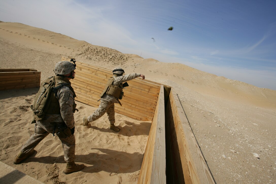 A Marine with Weapons Company, Battalion Landing Team 1st Battalion, 5th Marine Regiment, 11th Marine Expeditionary Unit, Camp Pendleton, Calif., throws an M67 fragmentation grenade at the Udairi Range Complex during sustainment training here Jan. 18