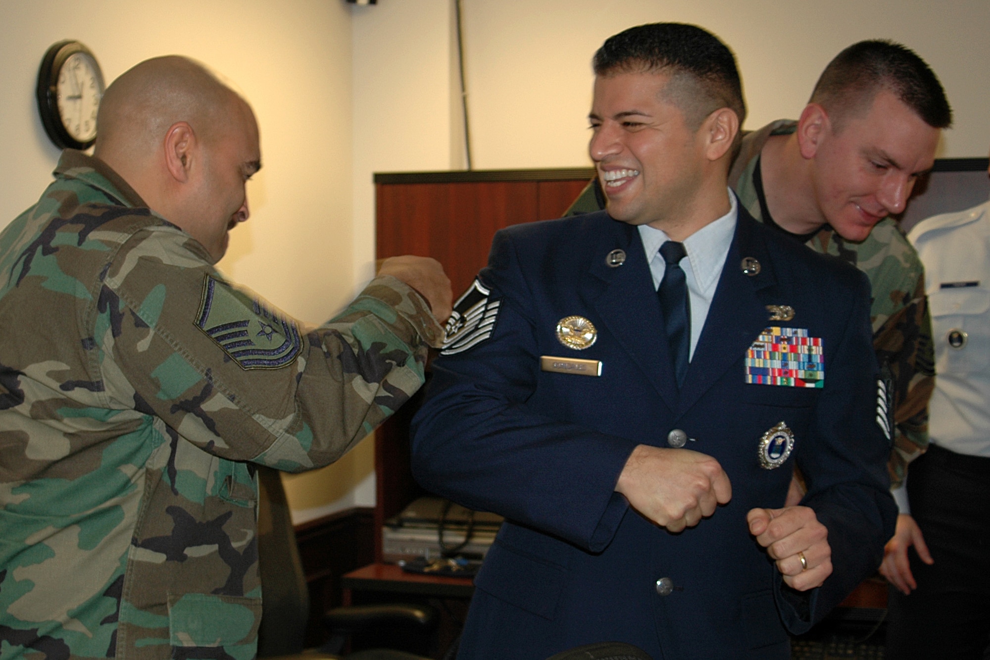Master Sgt. Brian Watt, 347th RCS operations NCO, braces newly minted Master Sgt. (select) Ruben J. Gonzales, Jr., an officer accessions recruiter, for Master Sgt. Kevin Edwards, the 347th operations flight chief, to tack on a new set of E-7 stripes so they stay put. (Air Force photo/Staff Sgt. Holly Schwartz, 347th RCS)