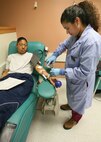 Esther Ramos, a phlebotomist, takes the blood of Airman Rosetta Loper, 324th Training Squadron, at the Lackland Blood Donor Center Jan. 15. The center is in need of blood of all types, for distribution to warfighters in Iraq and Afghanistan, as well as patients at Wilford Hall Medical Center. (USAF photo by Robbin Cresswell)
