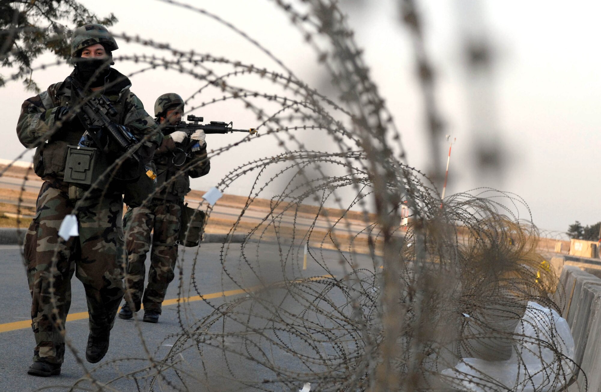 Senior Airmen Alejandro DeLaFuente (front) and Anthony Leonard (back) inspect the perimeter for enemy forces in a simulated attack on the wng operations center during the peninsula wide operational readiness exercise Jan. 17 at Kunsan Air Base, South Korea. The exercise is conducted to ensure members remain mission ready at all times. Both are members of the 8th Security Forces Squadron. (U.S. Air Force photo/Senior Airman Steven R. Doty)