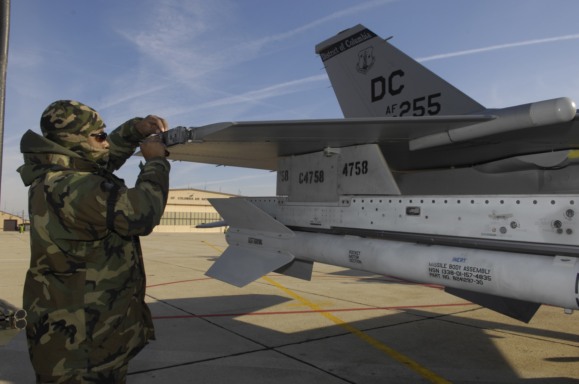 Tech. Sgt. Kevin Threat, 113th Maintenance Group electrical and environmental technician, removes an unservicable light bulb from its fixture on the tip of an F-16 Fighting Falcon assigned to the 113th Wing, District of Columbia Air National Guard on Jan. 15. (US Air Force/SrA Renae Kleckner)