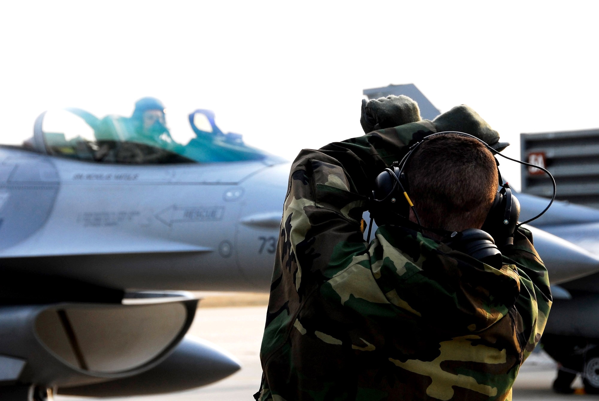 A member of the 8th Aircraft Maintenance Squadron marshals in an F-16 Fighting Falcon at Kunsan Air Base, South Korea, after a Jan. 18 flight from Eielson Air Base, Alaska. The 80th Fighter Squadron will be receiving 18 Common Configuration Implementation Program Block 40 jets from the Alaskan-based unit and Eielson AFB will in-turn receive the 80th FS Block 30 jets for an aggressor squadron. (U.S. Air Force photo/Tech Sgt. Quinton T. Burris)