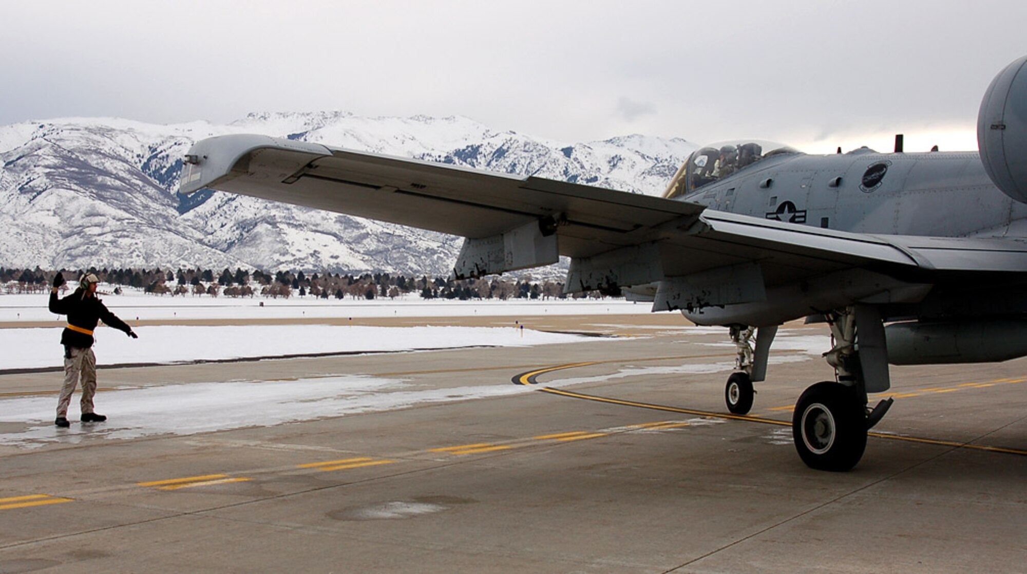 Andrew Selph guides Capt. Jesse McCulloch as he taxis aircraft 80-0172 onto the runway at Hill Air Force Base, Utah. Captain McCulloch flew the 100th upgraded A-10 Thunderbolt II to Moody AFB, Ga. The avionics and weapons system upgrades will now extend its service life until 2028. Mr. Selph is a crew chief with the 571st Aircraft Maintenance Squadron. (U.S. Air Force photo/Bill Orndorff) 