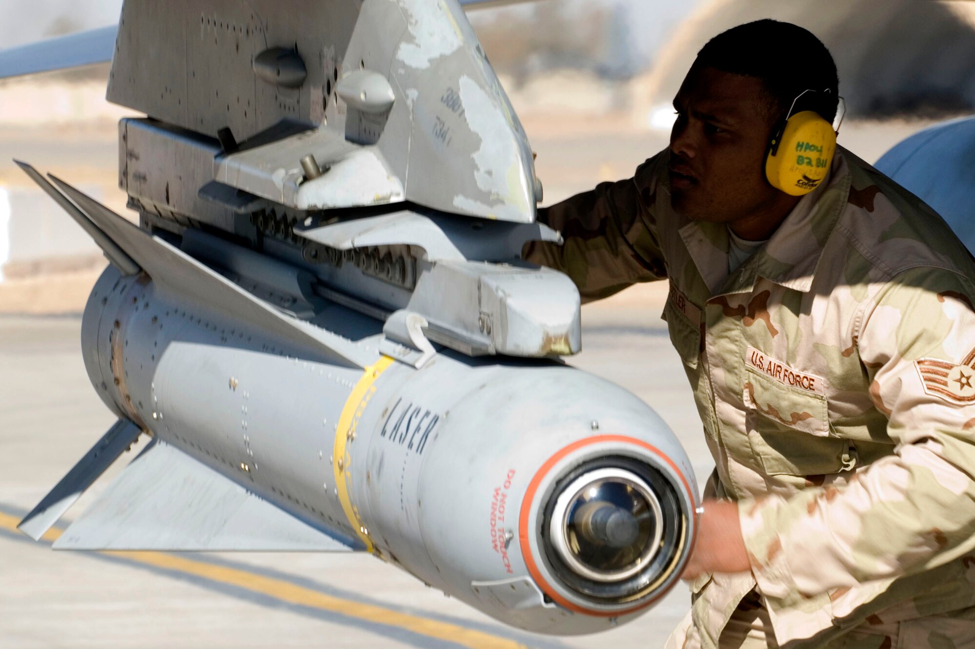 Staff Sgt. Kenneth Butler arms F-16 Fighting Falcon munitions prior to takeoff Jan. 16 at Balad Air Base, Iraq. Once armed, the aircraft took off for a combat mission over the Iraq. Sergeant Butler, a 332nd Expeditionary Maintenance Squadron aircraft armament specialist, is deployed from Hill Air Force Base, Utah. (U.S. Air Force photo/Staff Sgt. Joshua Garcia) 
