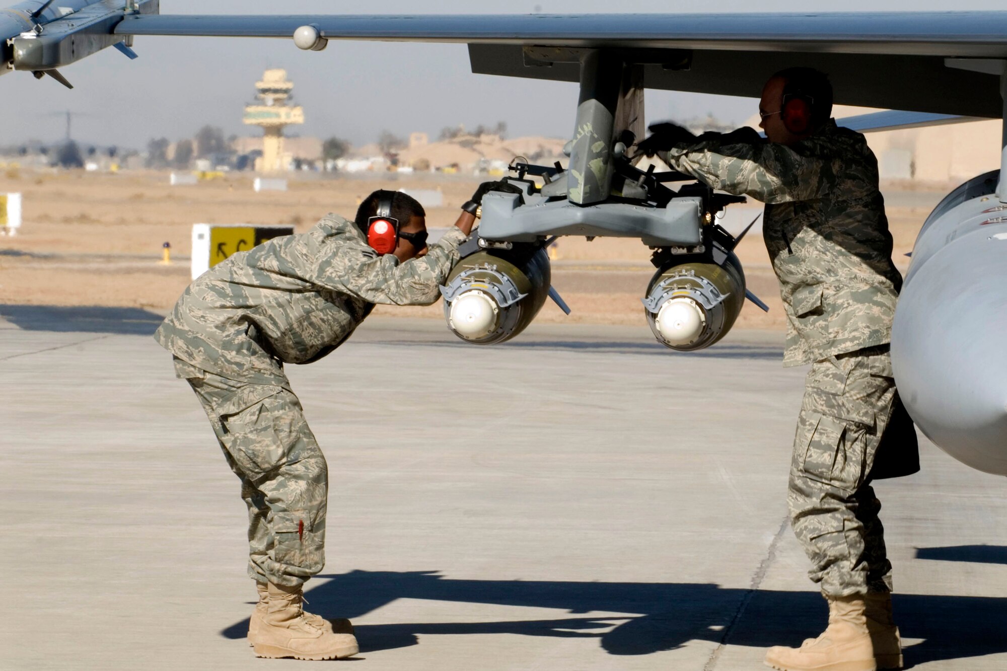 Airman 1st Class Mayuran Arunachalam and Staff Sgt. Michael Norton inspect F-16 Fighting Falcon munitions prior to takeoff Jan. 16 at Balad Air Base, Iraq. Munitions are inspected and armed prior to flights to ensure they are mission capable. Sergeant Norton and Airman Arunachalam, 332nd Expeditionary Maintenance Squadron aircraft armament specialists, are deployed from Hill Air Force Base, Utah. (U.S. Air Force photo/Staff Sgt. Joshua Garcia) 
