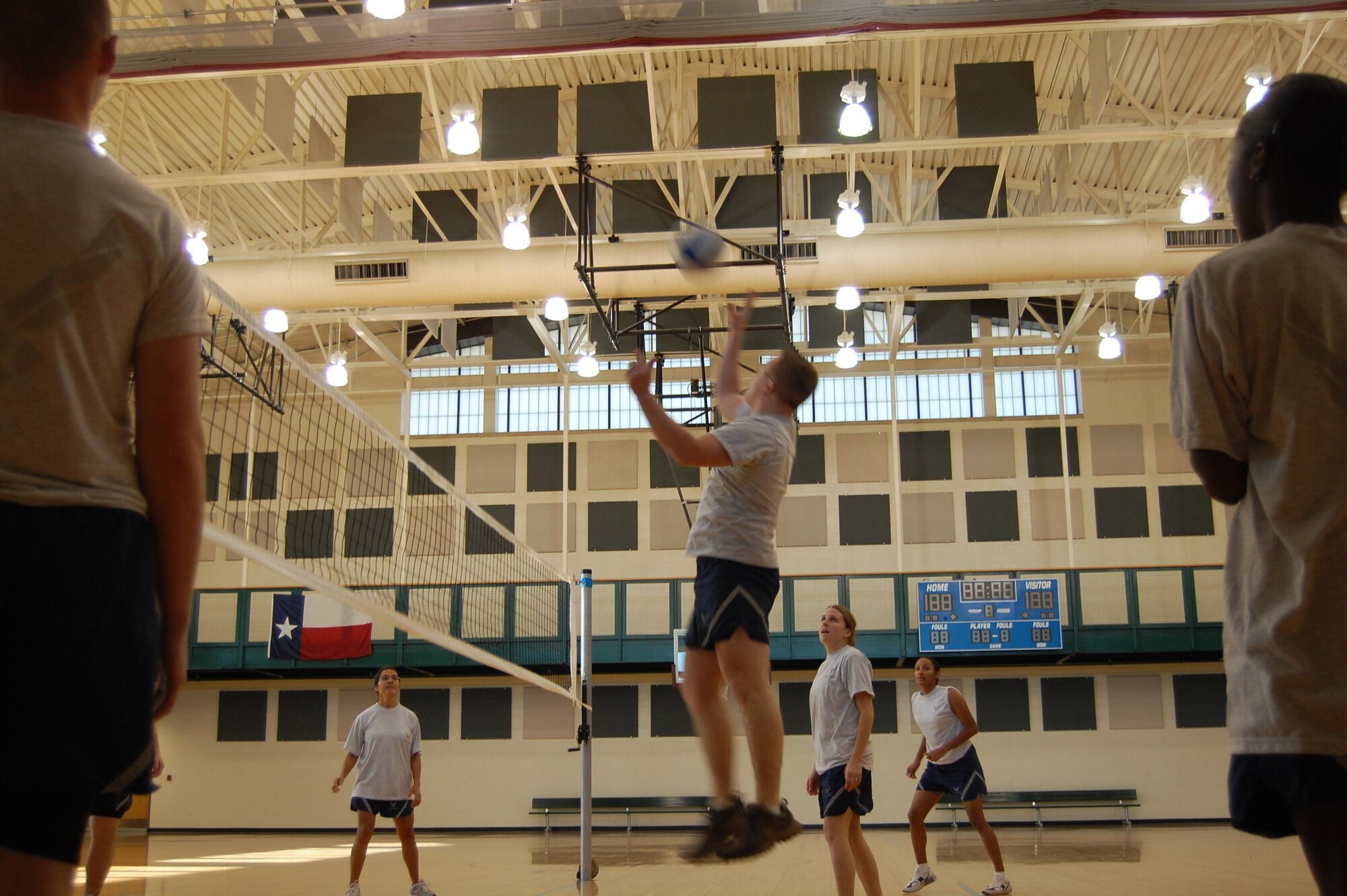 A member of the First Term Airman Class sets the ball for another team member to spike over the net during a friendly volleyball game between the FTAC and Top 3 team Jan. 16 at the Losano Fitness Center gym. Though, the undefeated Top 3 team was leading from the start, the game was cut short due to an injury.  The Top 3 versus FTAC volleyball game is organized to build esprit de corps and to acquaint new Airmen with their enlisted leaders at Laughlin. (U.S. Air Force photo by Senior Airman Olufemi Owolabi)
