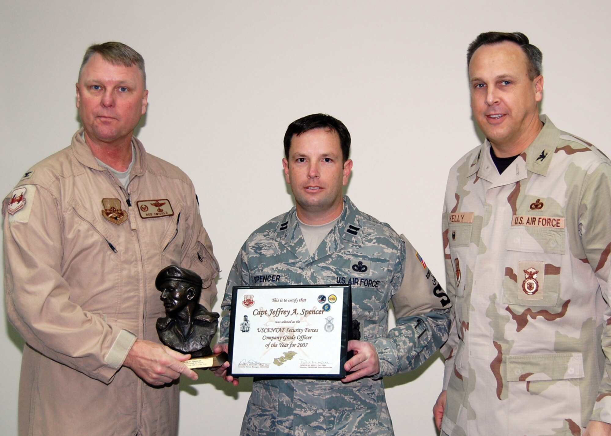 SOUTHWEST ASIA -- Capt. Jeff Spencer, 386th Expeditionary Security Forces Squadron, is presented the Outstanding Security Forces Company Grade Officer of the Year award for U. S. Central Command Air Forces on Jan. 18. Colonel Robert Swisher (left), 386th Air Expeditionary Wing commander and Col. Mike Kelly (right), USCENTAF force protection, presented him the award. (U.S. Air Force photo/Tech. Sgt. Michael O'Connor)