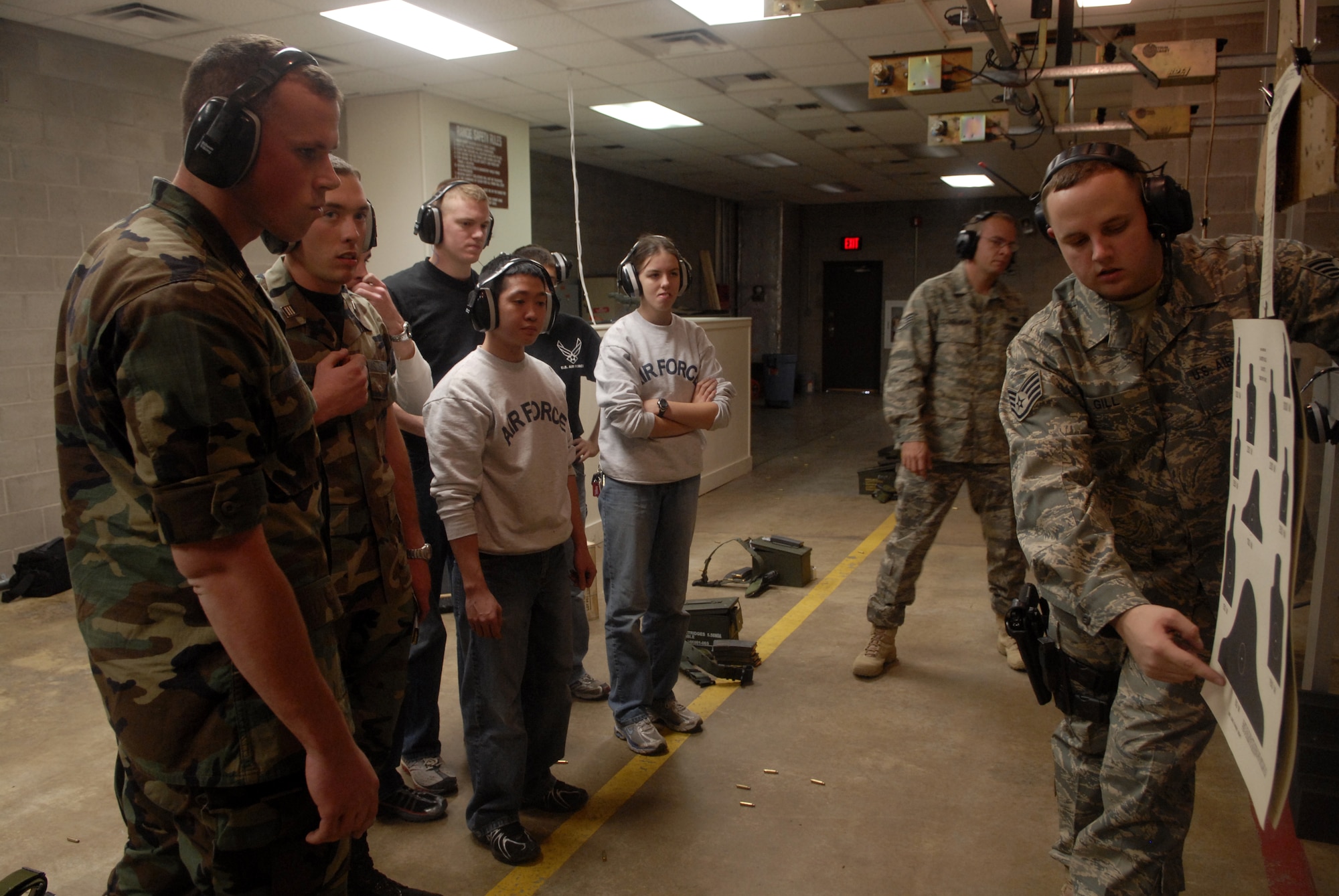 Staff Sgt. Robert Gill, a combat arms instructor with the 17th Security Forces Squadron, discusses firing results with cadets during training at the base firing range. (U.S. Air Force photos by Airman 1st Class Kamaile Chan)