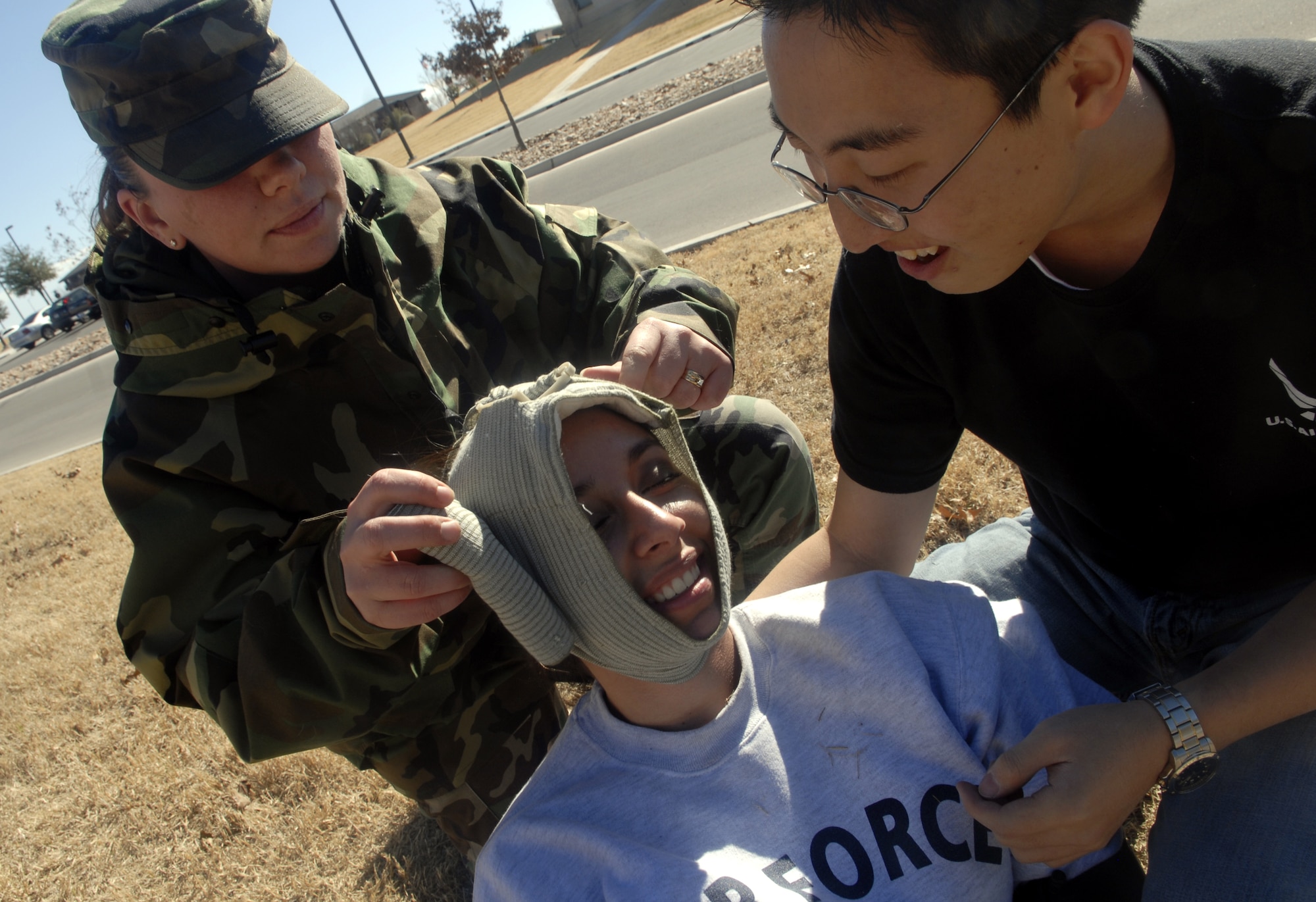 Staff Sgt. Michelle Abrahamsson of the 17th Medical Operations Squadron assists Cadets Siara Ruiz and David Chung during an exercise using Self-Aid and Buddy Care at the Vance Deployment Center Jan. 10. (U.S. Air Force photo by Airman 1st Class Kamaile Chan)