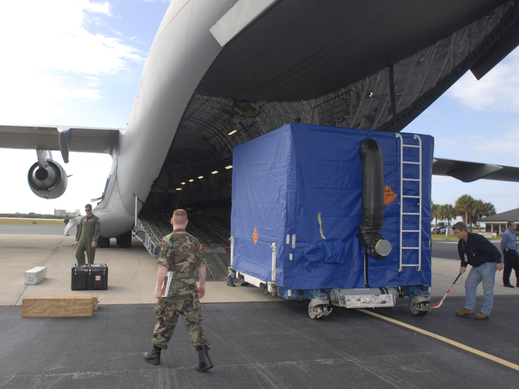 Air Force and contractor personnel observe as GPS satellite IIR-M 20, safely housed in its shipping container, is offloaded Jan. 10 at Cape Canaveral AFS. (U.S. Air Force photo by Tony Gray)