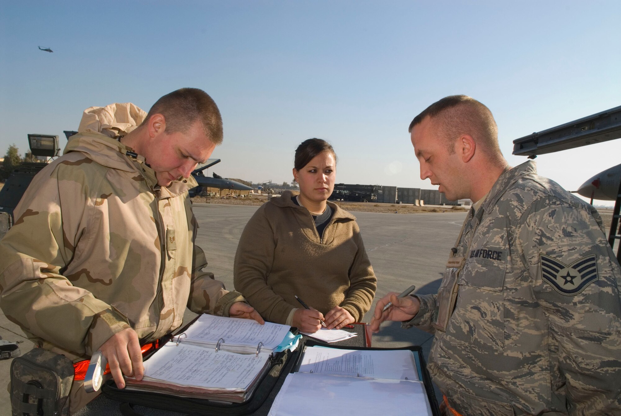 BALAD AIR BASE, Iraq -- Staff Sgt. Clint Sickel, a 332nd Expeditionary Maintenance Group quality assurance technician, right, briefs Staff Sgt. Raymond Garlick and Senior Airman Renee Hoover, 332nd Expeditionary Aircraft Maintenance Unit crew chiefs, prior to a personnel evaluation for Airman Hoover here, Jan. 17. Personnel evaluations ensure crew chiefs receive feedback on their career field proficiency. The Airmen are deployed from Spangdahlem Air Base, Germany. (U.S. Air Force photo/Staff Sgt. Joshua Garcia)