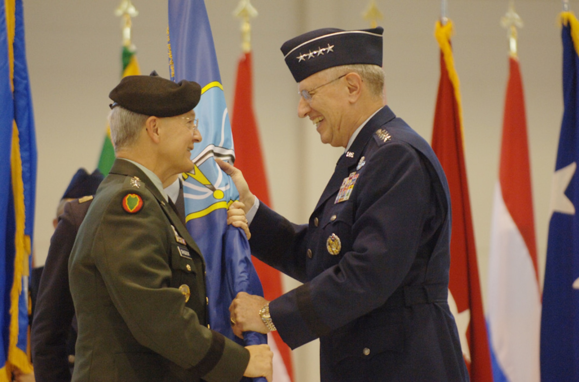 General Roger A. Brady accepts the NATO Allied Air Component flag from Gen. John Craddock, Supreme Allied Commander, Europe, during the Jan. 17 assumption of command ceremony at Ramstein Air Base, Germany.  As USAFE commander, Gen. Brady also has three other titles: commander, Allied Air Component Command Ramstein; air component commander, U.S. European Command, Ramstein AB, Germany; and director, Multinational Joint Air Power Competence Center, Kalkar, Germany. (Photo by Master Sgt. D. Scott Wagers, USAF)