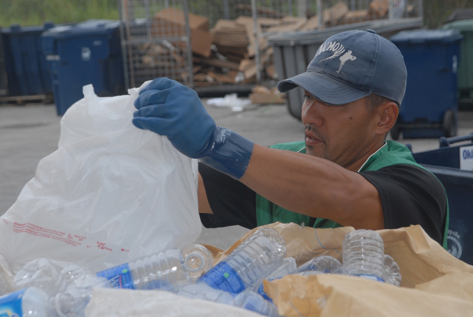 Leo Yozak, with Kadena’s recycling center, works to separate plastic bottles from a large shipment of recycling materials Jan. 16. The center accepts plastic, Styrofoam, glass, aluminum and other materials from Kadena Air Base for the wing recycling program. (U.S. Air Force photo/Staff Sgt. Christopher Marasky)