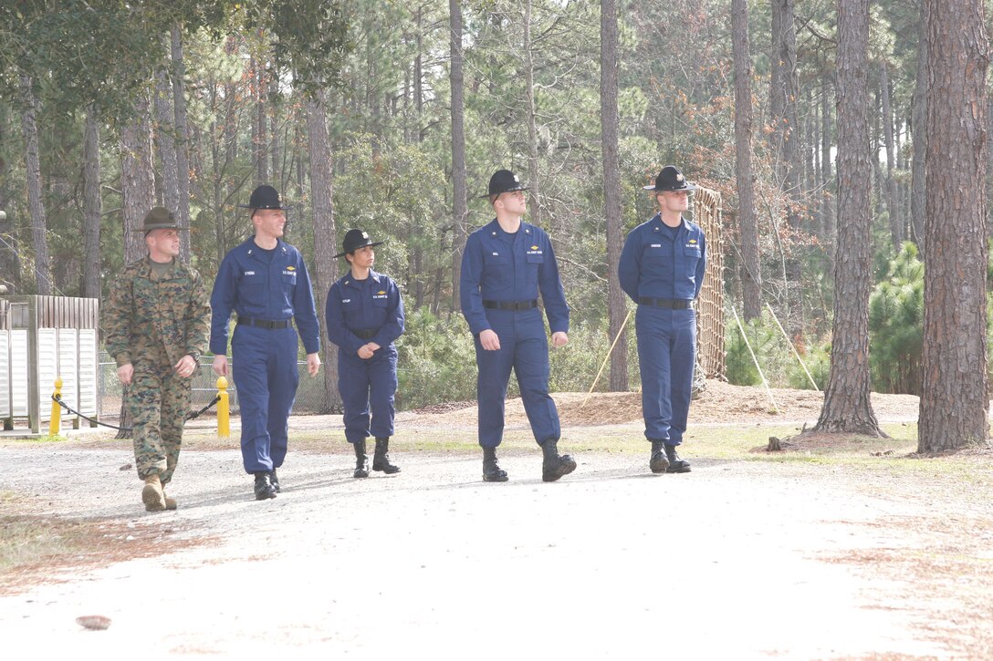 Coast Guardsmen from the Coast Guard Training Center in Cape May, N.J.,  take a walk-through tour of the Confidence Course with their escort, Gunnery Sgt. David Labonte, during a previous visit in January. The Coast Guard is revamping their basic training program, and has made several trips to the Depot to learn more about Marine Corps training and how they can apply it to their program.