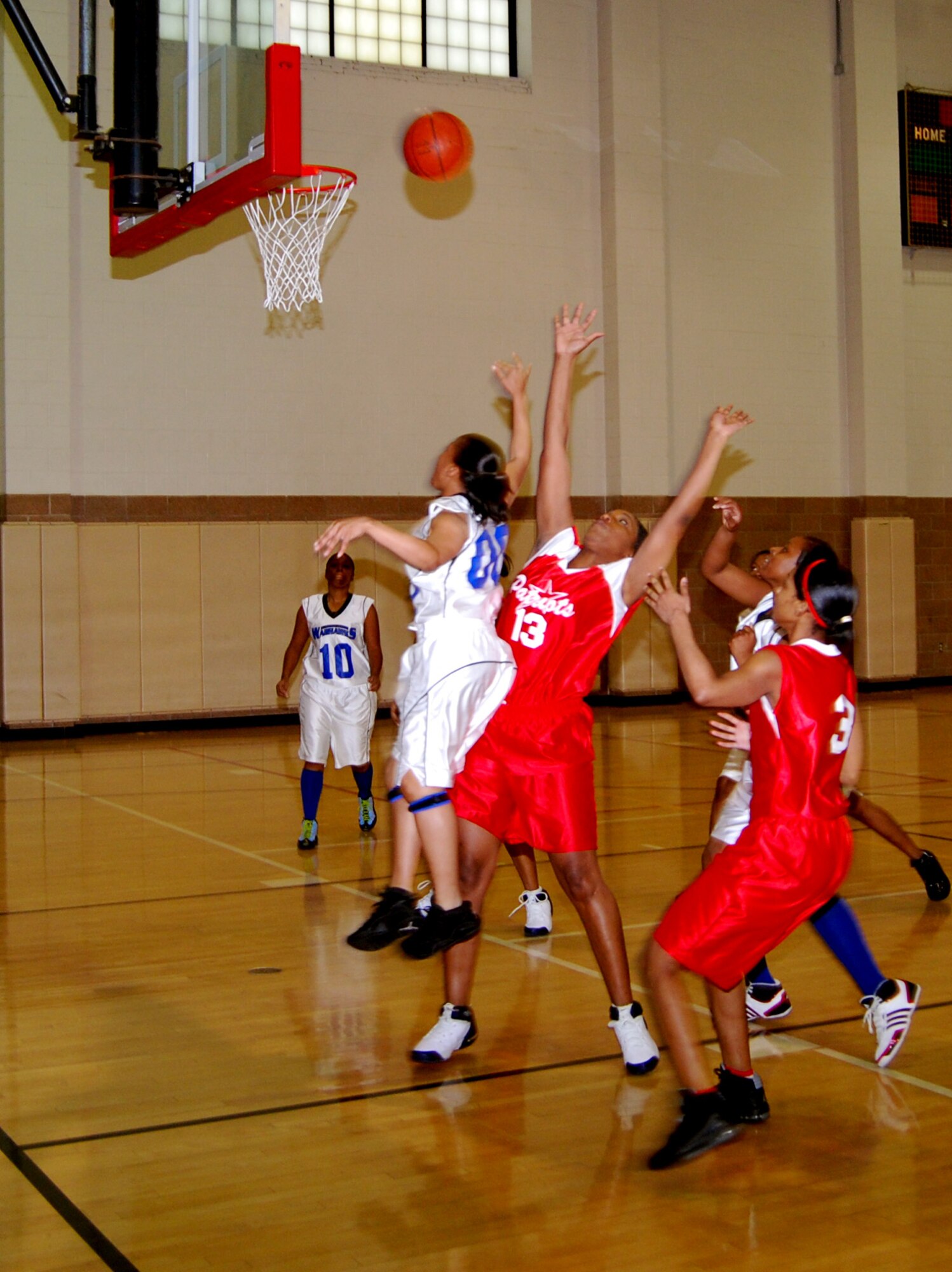 Peaches Dismuke, white, from Lackland Air Force Base, Texas, drives around April Copeland during a matchup between the Lackland Lady Warhawks and Altus Lady Patriots. Lackland won the opening game of the women's bracket of the 2008 Dr. Martin Luther King Jr. basketball tournament. (U.S. Air Force photo/John Ingle)