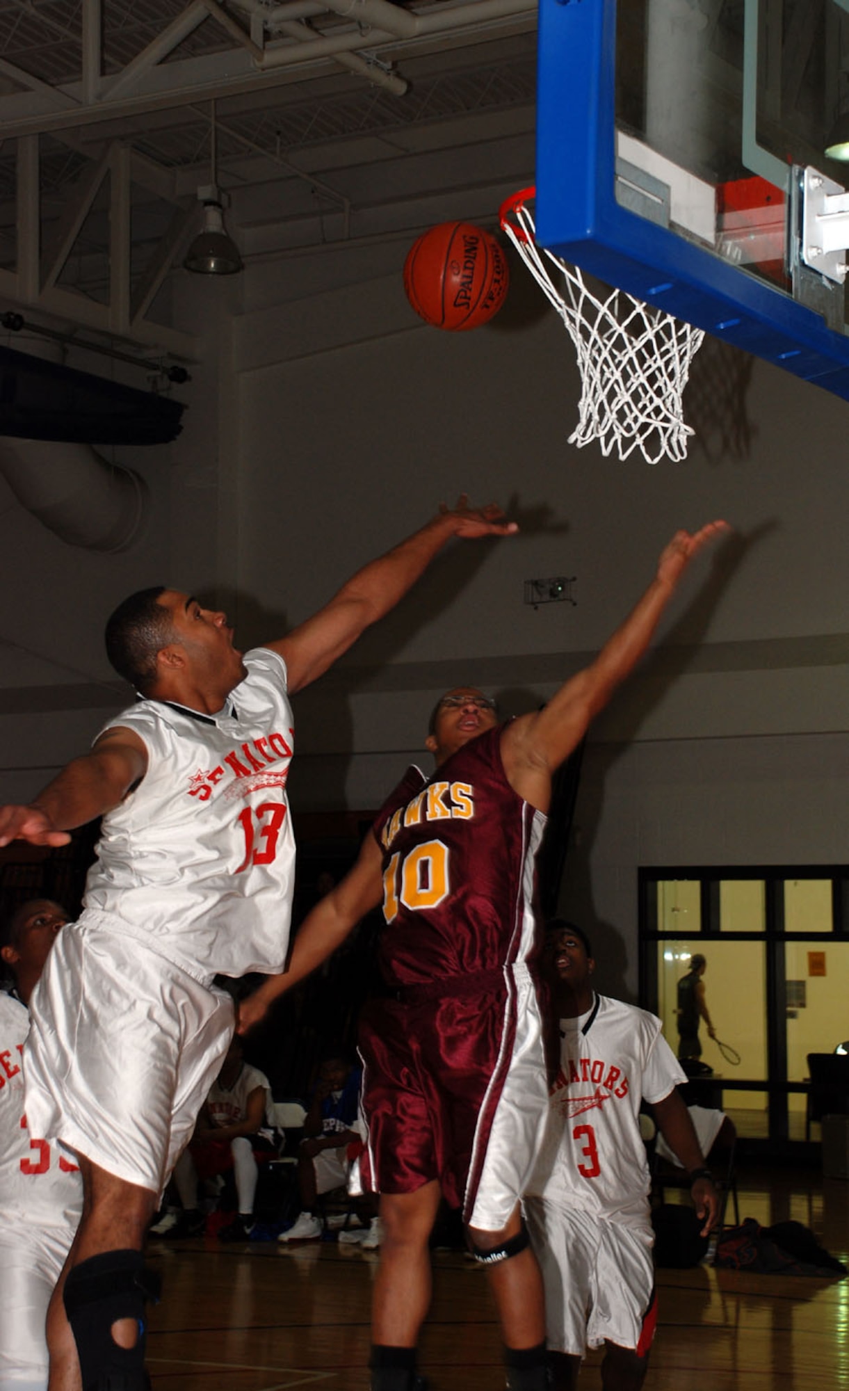 Johnny Cohnes of the Sheppard Senators and Tinker Air Force Base Hawks' Gerard West jump to catch a rebound during the annual Dr. Martin Luther King Jr. tournament Jan. 19. The Senators defeated the Hawks, 86-73. (U.S. Air Force photo/Airman 1st Class Jacob Corbin)