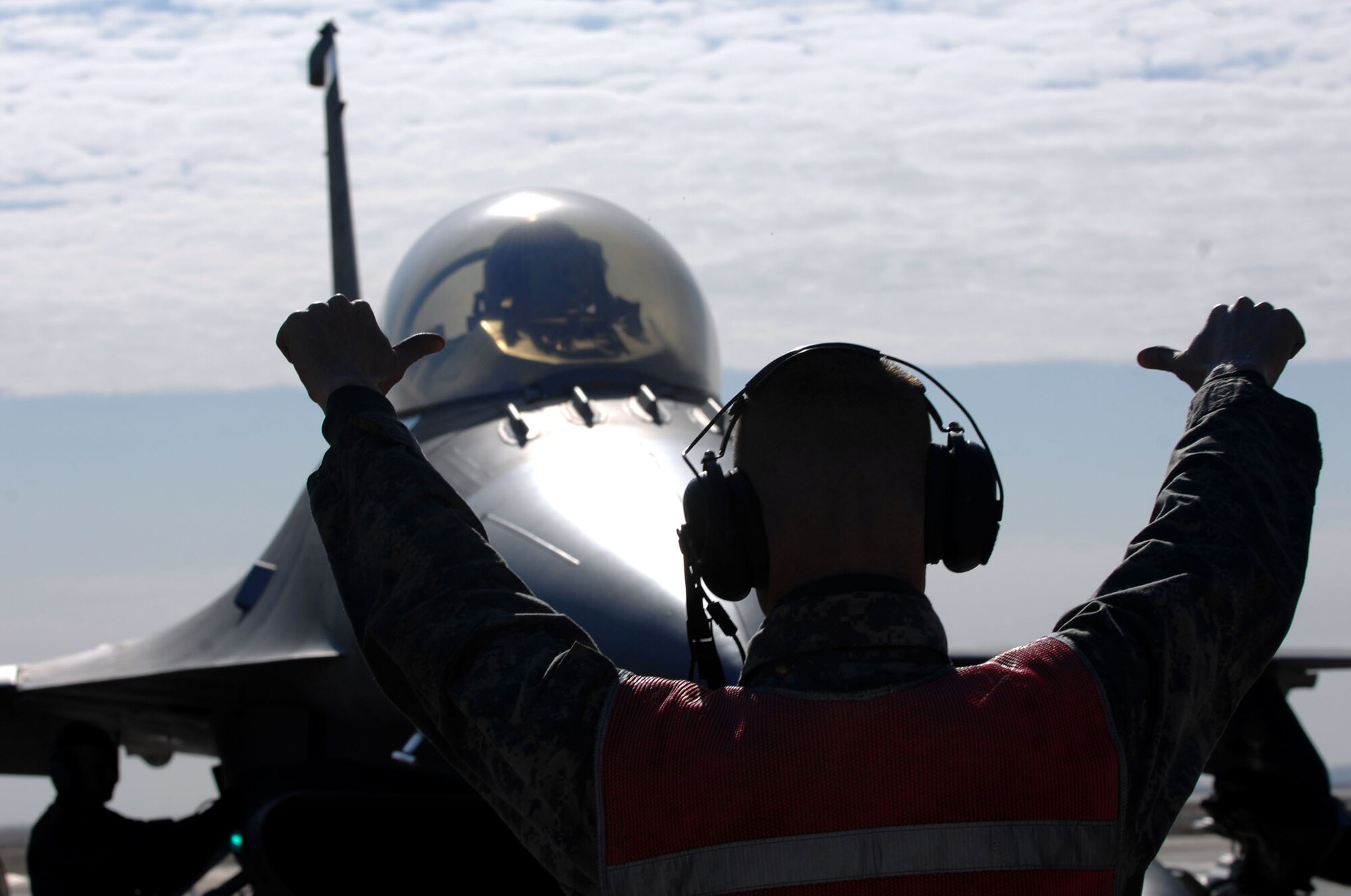 BALAD AIR BASE, Iraq -- Staff Sgt. Jeremy Lewis, a 332nd Expeditionary Aircraft Maintenance Unit crew chief, gives the "chalks in" signal to Capt. Travis "Bandit" Keenan, a 22nd Fighter Squadron pilot, before de-arming his F-16 Fighting Falcon here, Jan. 19. Communication between crew chiefs and fighter pilots is done via head sets and hand signals. Both Sergeant Lewis and Captain Keenan are from Spangdahlem Air Base, Germany.(U.S. Air Force photo by Senior Airman Julianne Showalter) 
