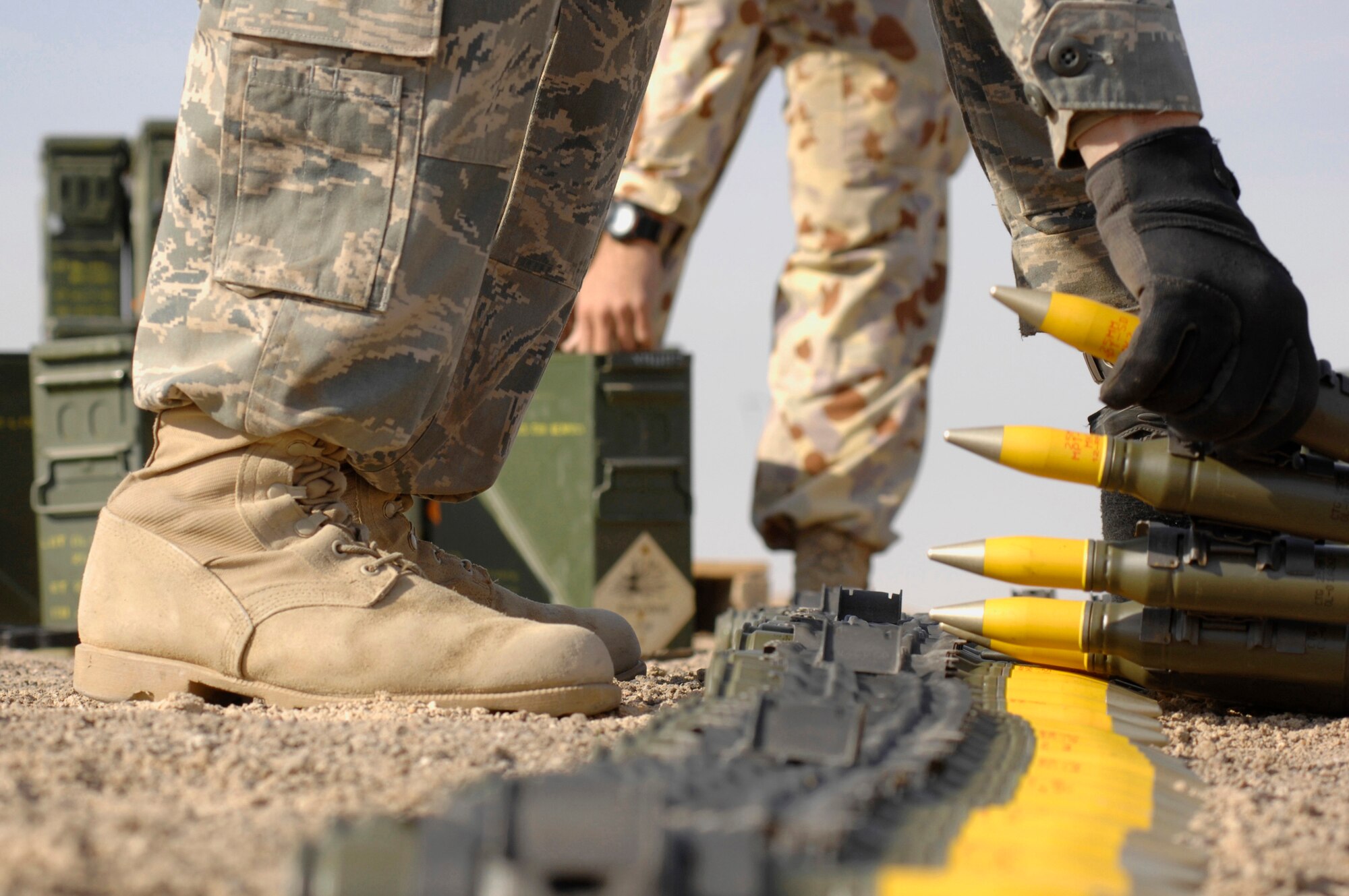 Senior Airman Charles Howell, 386th Expeditionary Civil Engineer Squadron explosive ordnance disposal flight, handles ammunition that is set to be destroyed during a controlled detonation with coalition forces from the Australian Army Force Level Logistic Asset Jan. 18 at an explosive ordnance disposal range in the Persian Gulf Region.  The controlled detonation is destroying unserviceable munitions. (U.S. Air Force photo/Senior Airman Patrick Dixon)