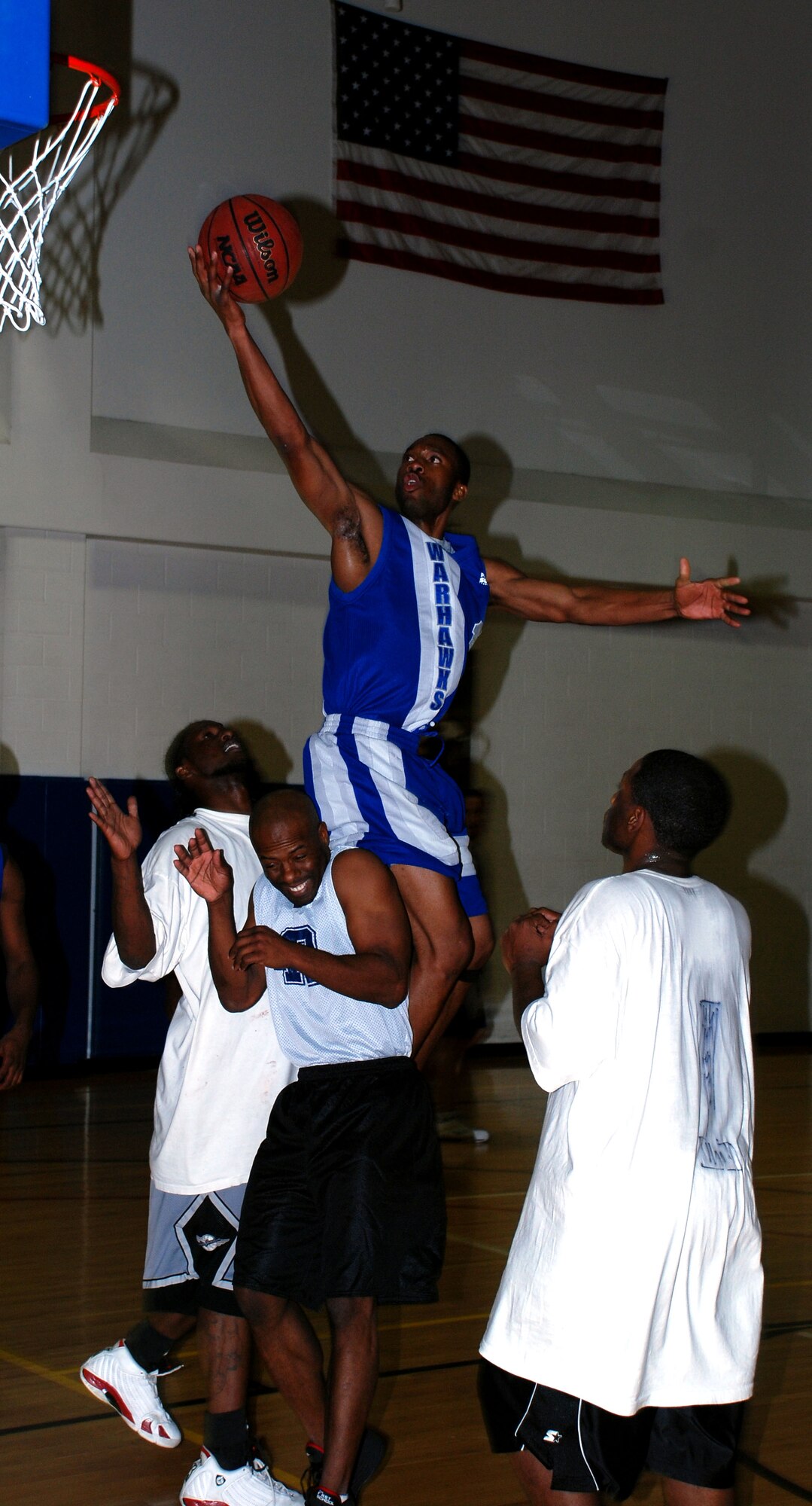 Rodrick Greene from Lackland Air Force Base, Texas, flies to the rim over Altus Dream Team players Jan. 20 during the annual Dr. Martin Luther King Jr. basketball tournament. (Lackland beat Altus 71-57 to advance to the finals against Cannon Air Force Base, N.M. (U.S. Air Force photo/Airman 1st Class Jacob Corbin)