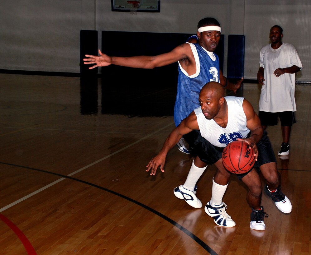 Eric Madden of the Altus Dream Team slips past Lackland Air Force Base's Ezell Trammel during the annual Dr. Martin Luther King Jr. basketball tournament Jan. 20. Lackland beat Altus 71-57 to advance to the MLK finals against Cannon Air Force Base, N.M. (U.S. Air Force photo/Airman 1st Class Jacob Corbin)