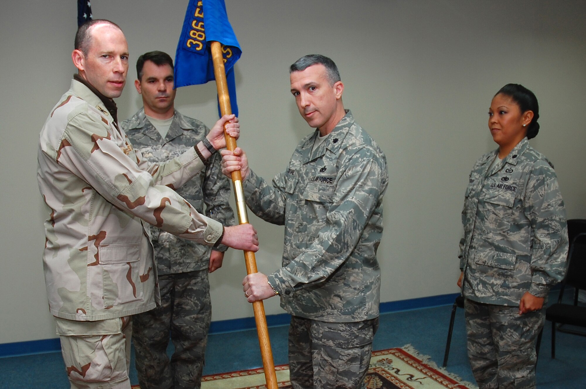 Col. Charles Westgate, 386th Expeditionary Maintenance Group Commander, hands Lt. Col. David Pastore the squadron guidon during the 386th Expeditionary Aircraft Maintenance Squadron change of command here Jan. 21, 2008. Lt. Col. David Pastore assumes command from Lt. Col. Shirlene Ostrov. (U.S. Air Force photo/ Senior Airman Patrick Dixon) (Released)