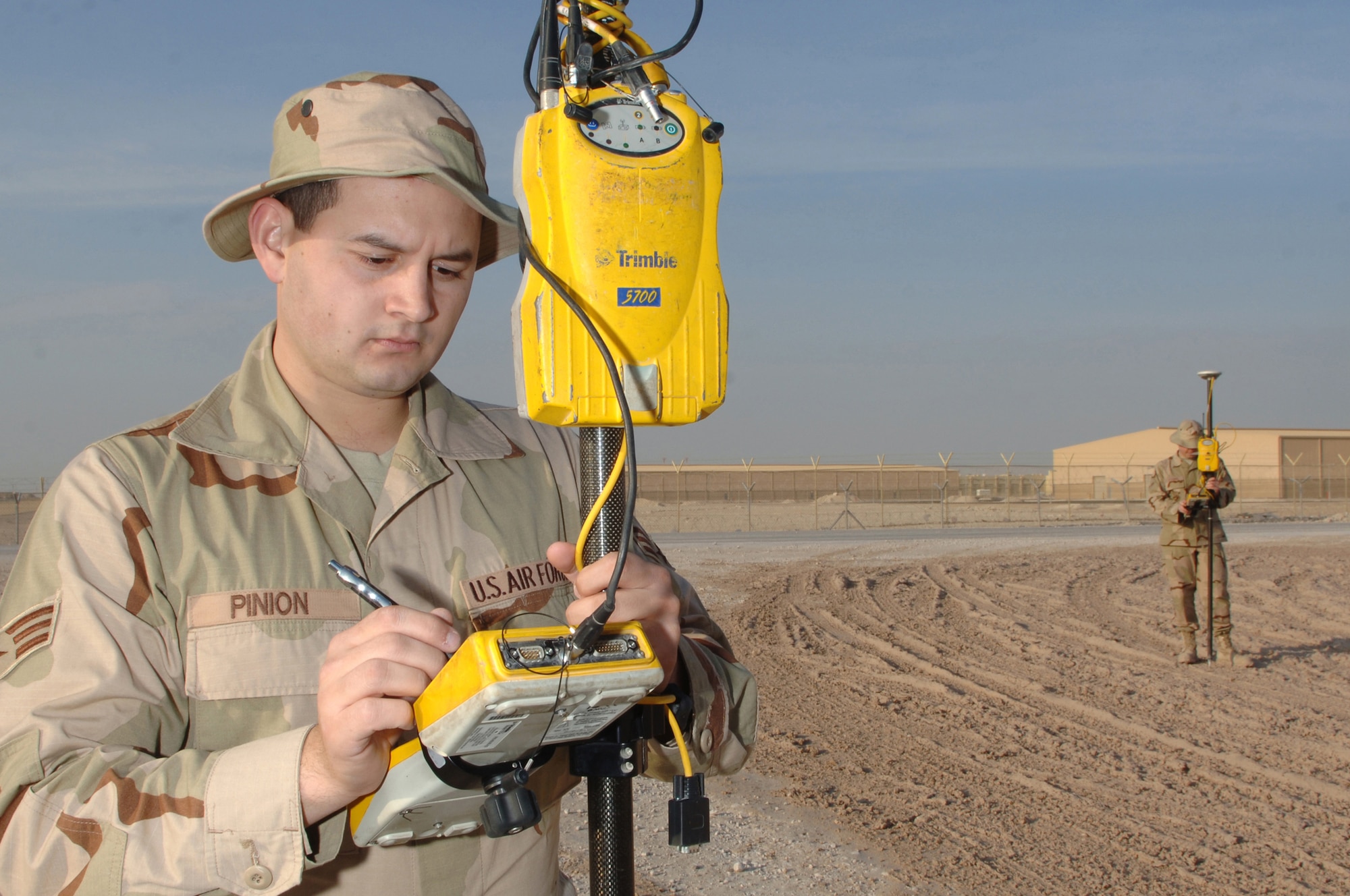 Senior Airman Cody Pinion and Airman First Class Brian J. Young, 379th Expeditionary Civil Engineer Squadron, prepare a Global Positioning System survey rover to accurately plot unmarked roads for a base map Jan. 17 at a Southwest Asia air base.  Airman Pinion is deployed from Scott Air Force Base, Ill. and Airman Young is deployed from Ramstein Air Base, Germany.  (U.S. Air Force photo/Tech. Sgt. Johnny L. Saldivar)