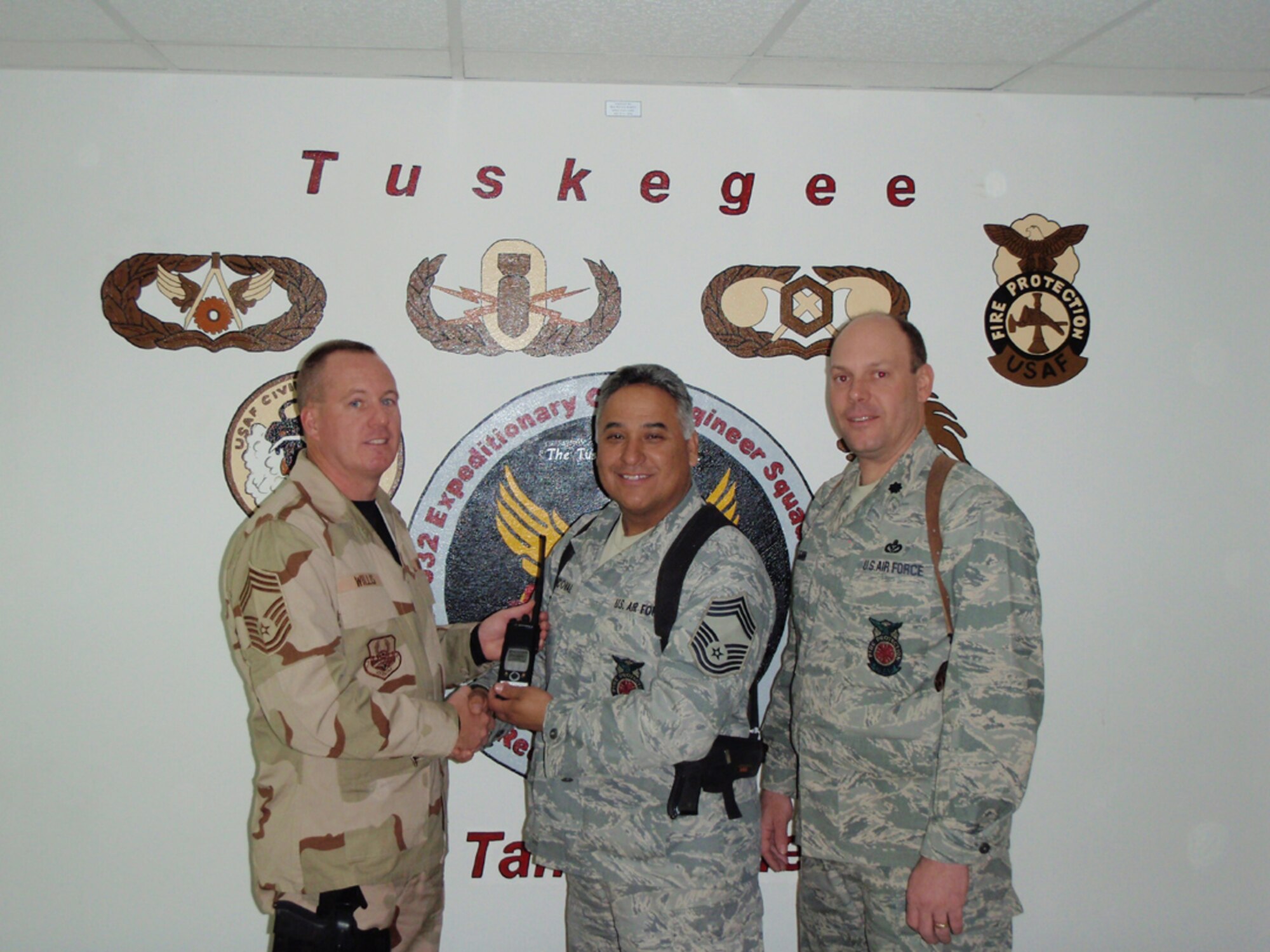BALAD AIR BASE, Iraq -- Chief Master Sgt. Douglass Willis (left) assumes the role of fire chief at Balad Air Base from Chief Master Sgt. David Sandoval. Lt. Col. Jeffrey Ullman (right), squadron commander for the 332nd presided over the ceremony. Chief Willis is one of ten reservists from the 916th Air Refueling Wing to deploy recently to the Middle East. U.S. Air Force photo/Senior Master Sgt. Donald Knuth