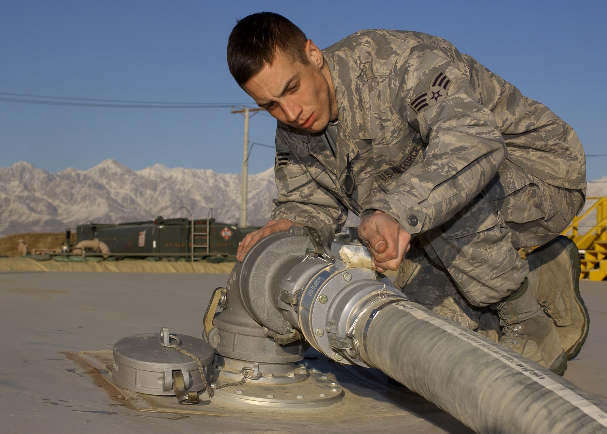 BAGRAM AIR BASE, Afghanistan - Senior Airman Aaron Ferguson closes a valve after transferring fuel fom a fuel bladder Jan. 19. Ferguson is a Fuels Specialist deployed here from the 97th Logistics Readiness Squadron, Altus Air Force Base, OK.  (U.S. Air Force photo by Master Sgt. Demetrius Lester)