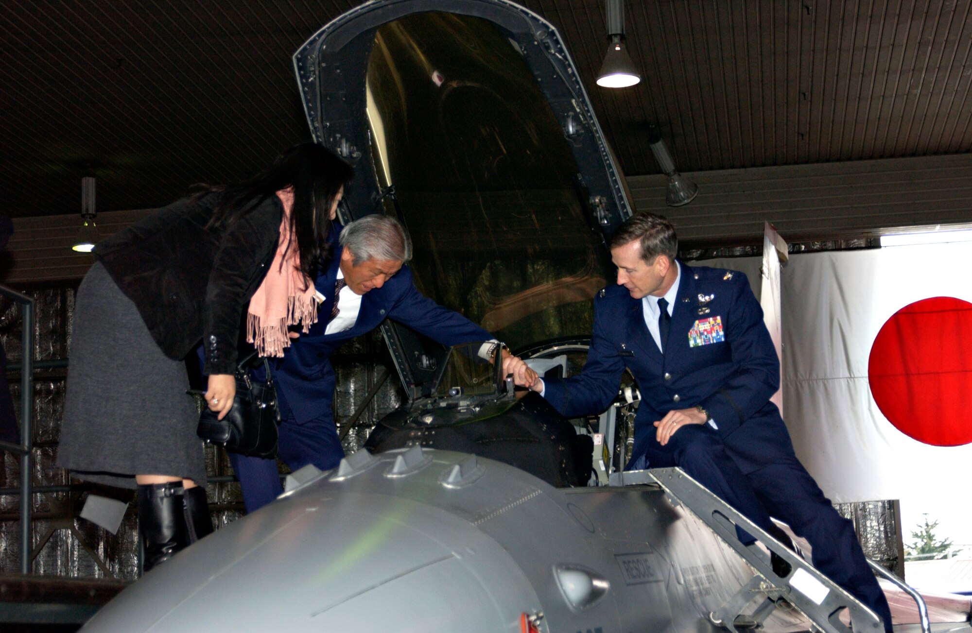 MISAWA AIR BASE, Japan -- Col. Terrence O'Shaughnessy, 35th Fighter Wing Commander, helps Mayor Shotaro Mimura, Oirase Town, into an F-16 setup as a static display in Hangar 911 on Jan. 22, 2008. Mayor Mimura was visiting with the Liaison Committee for the annual Mayors' luncheon. (U.S. Air Force photo by Airman 1st Class Eric Harris)